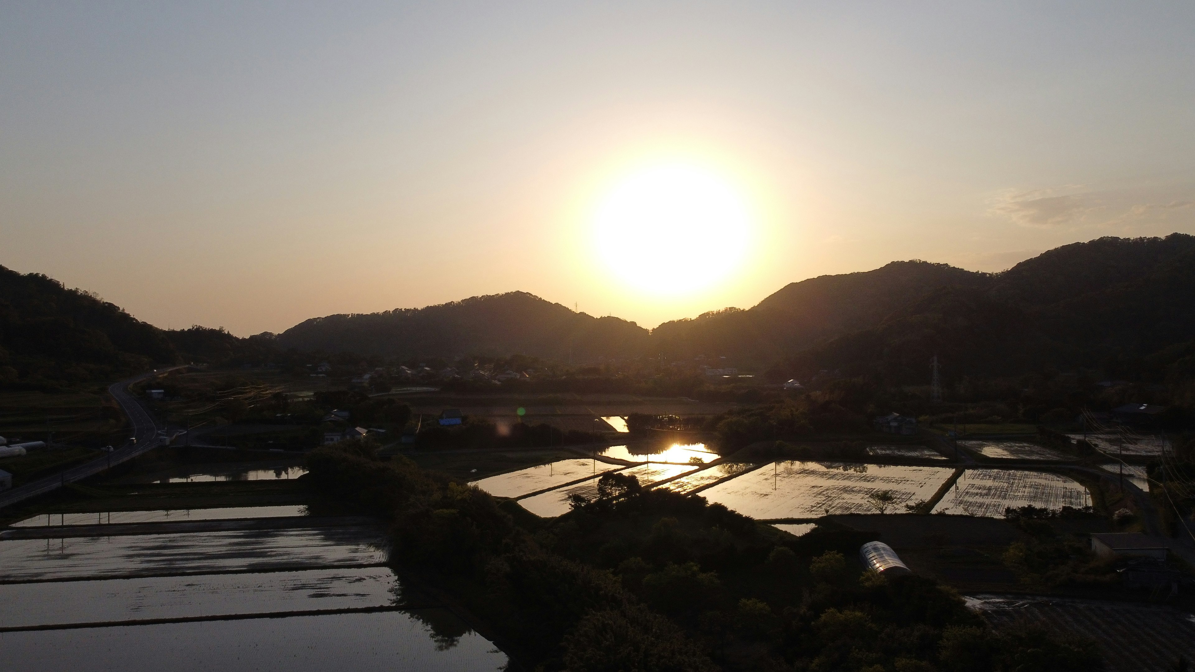 아름다운 일몰이 산 위에 비치고 논에 반사되는 풍경