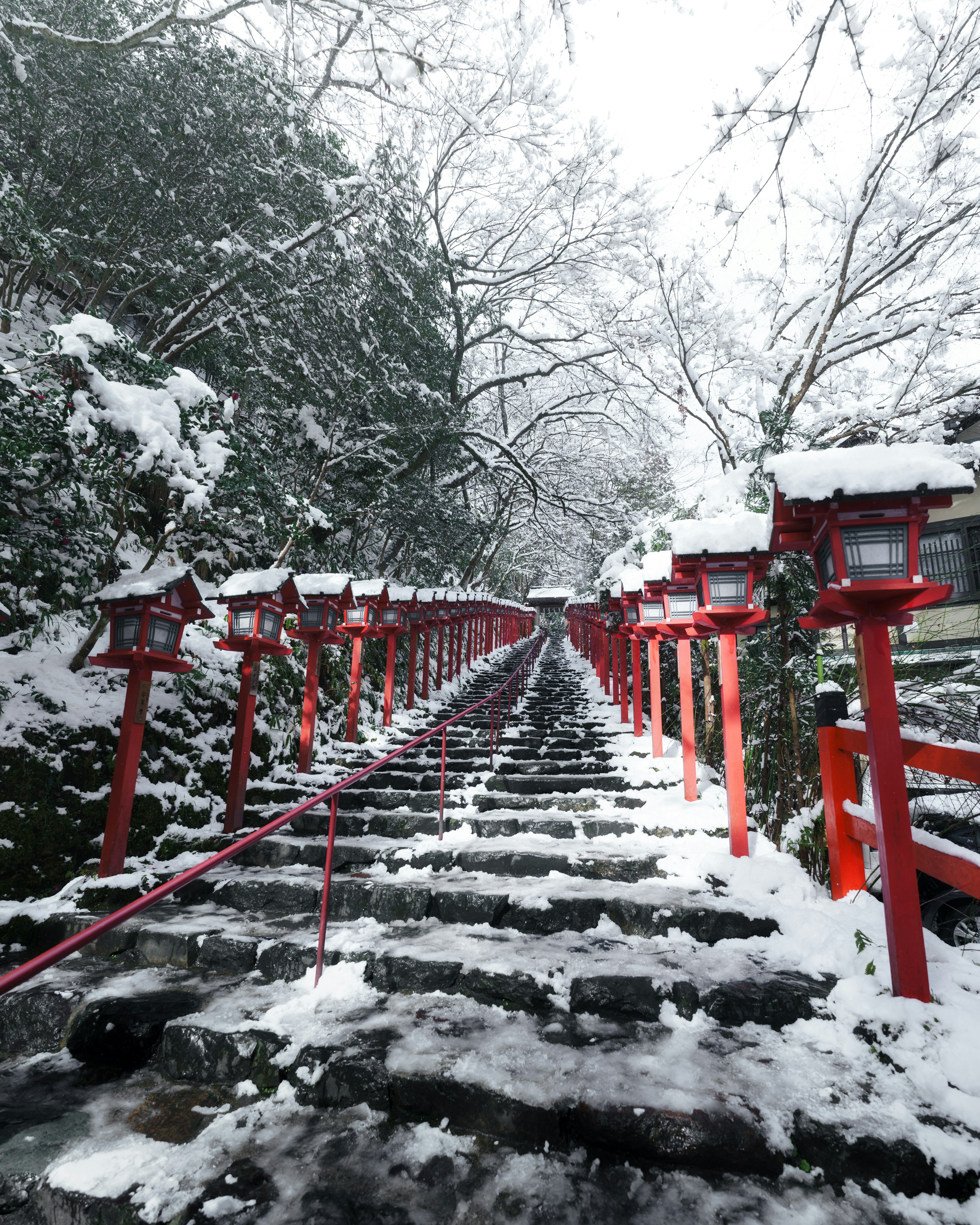 被雪覆盖的楼梯和红色灯笼