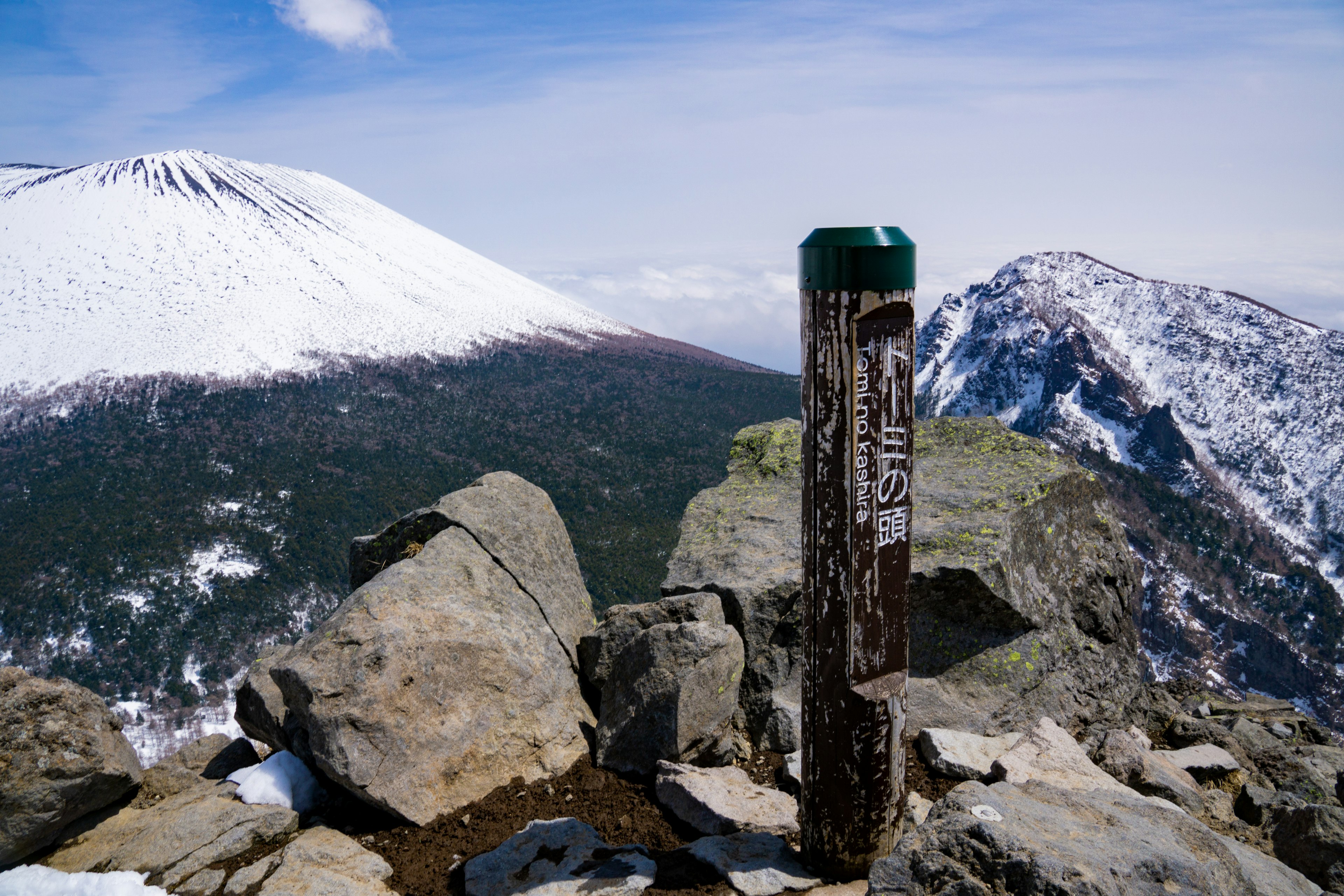 Snow-capped mountain landscape with a trail marker