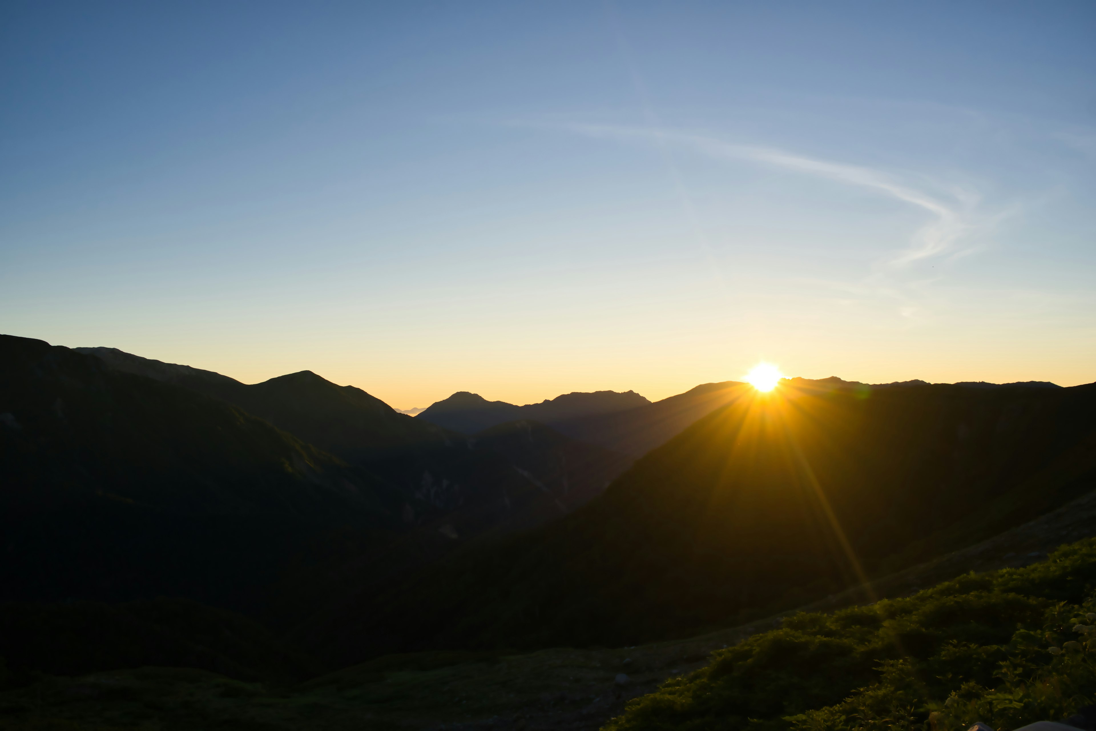 Sunrise over mountains with clear blue sky