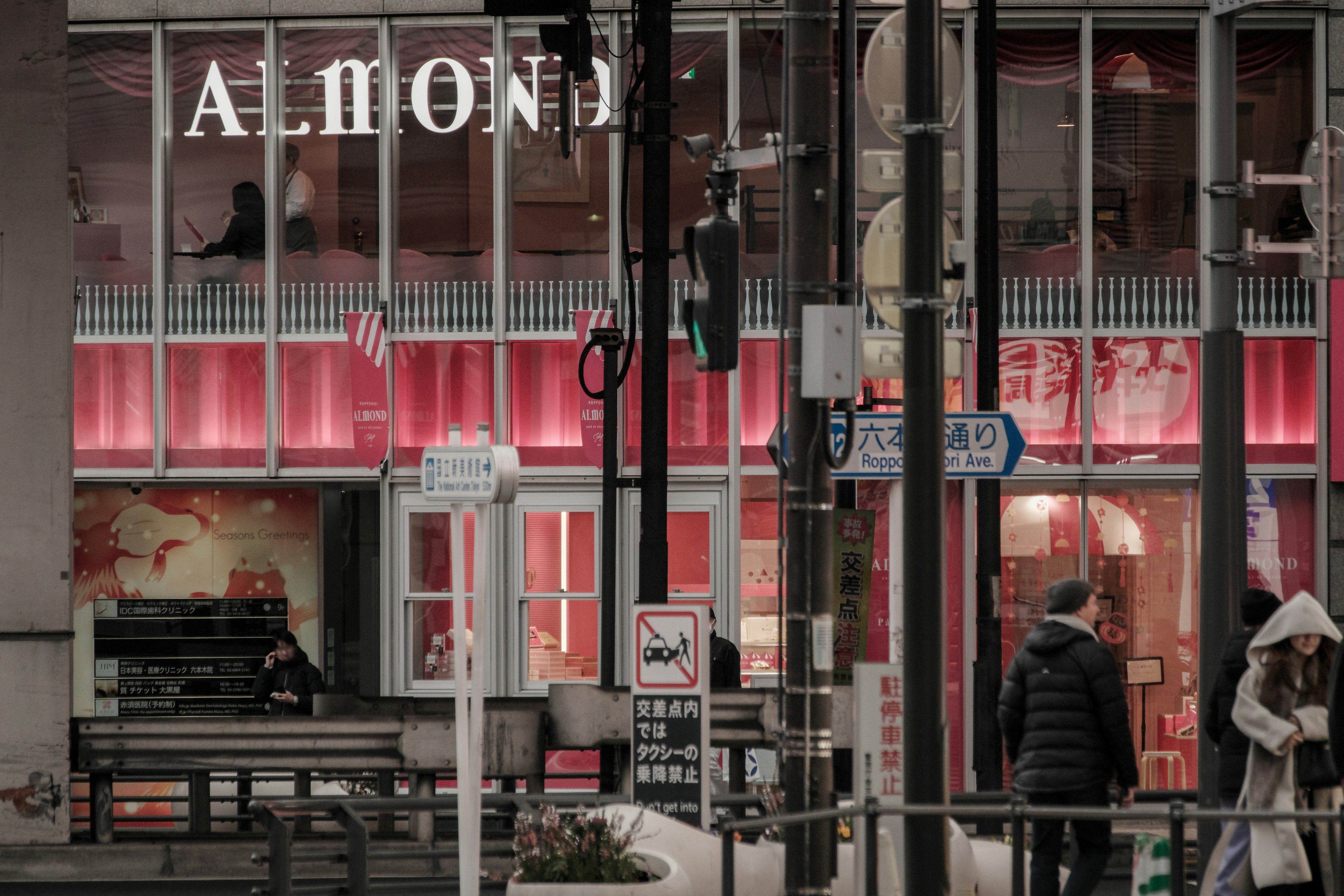 赤い照明に照らされたALMONDの店舗前の通りの風景