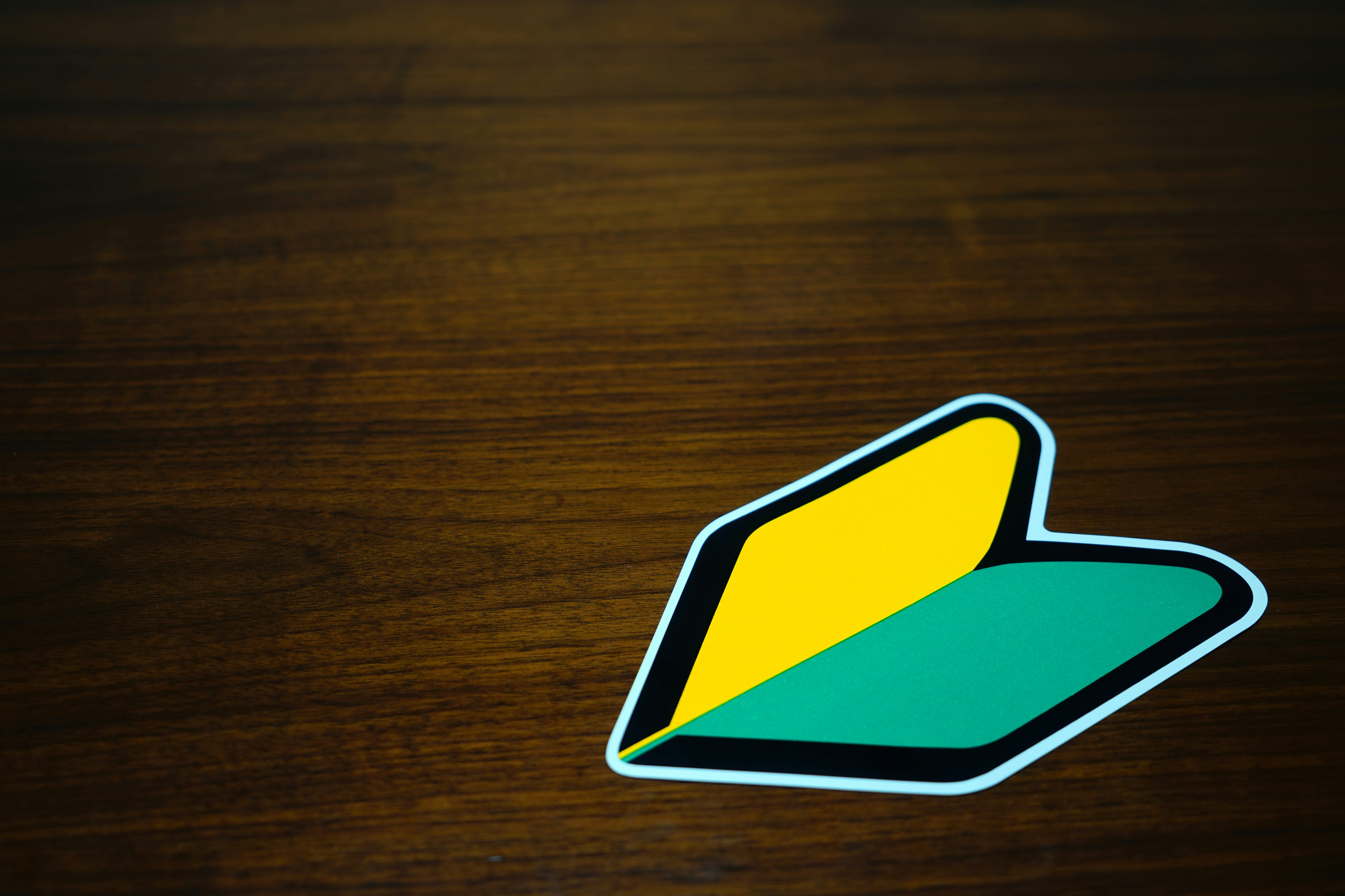 Un logo amarillo y verde sobre una mesa de madera