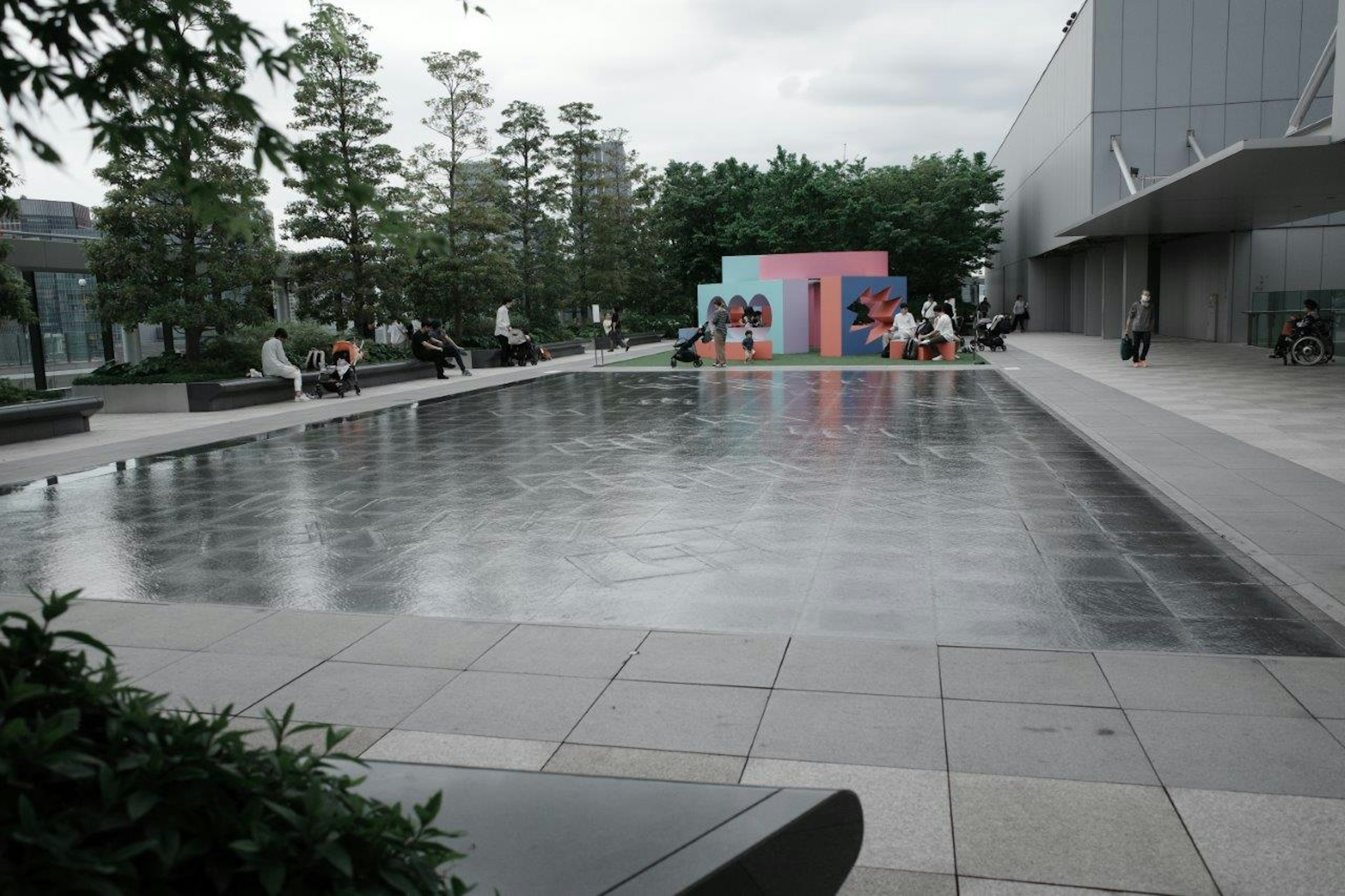 広い水面とカラフルな背景のある公園の景色