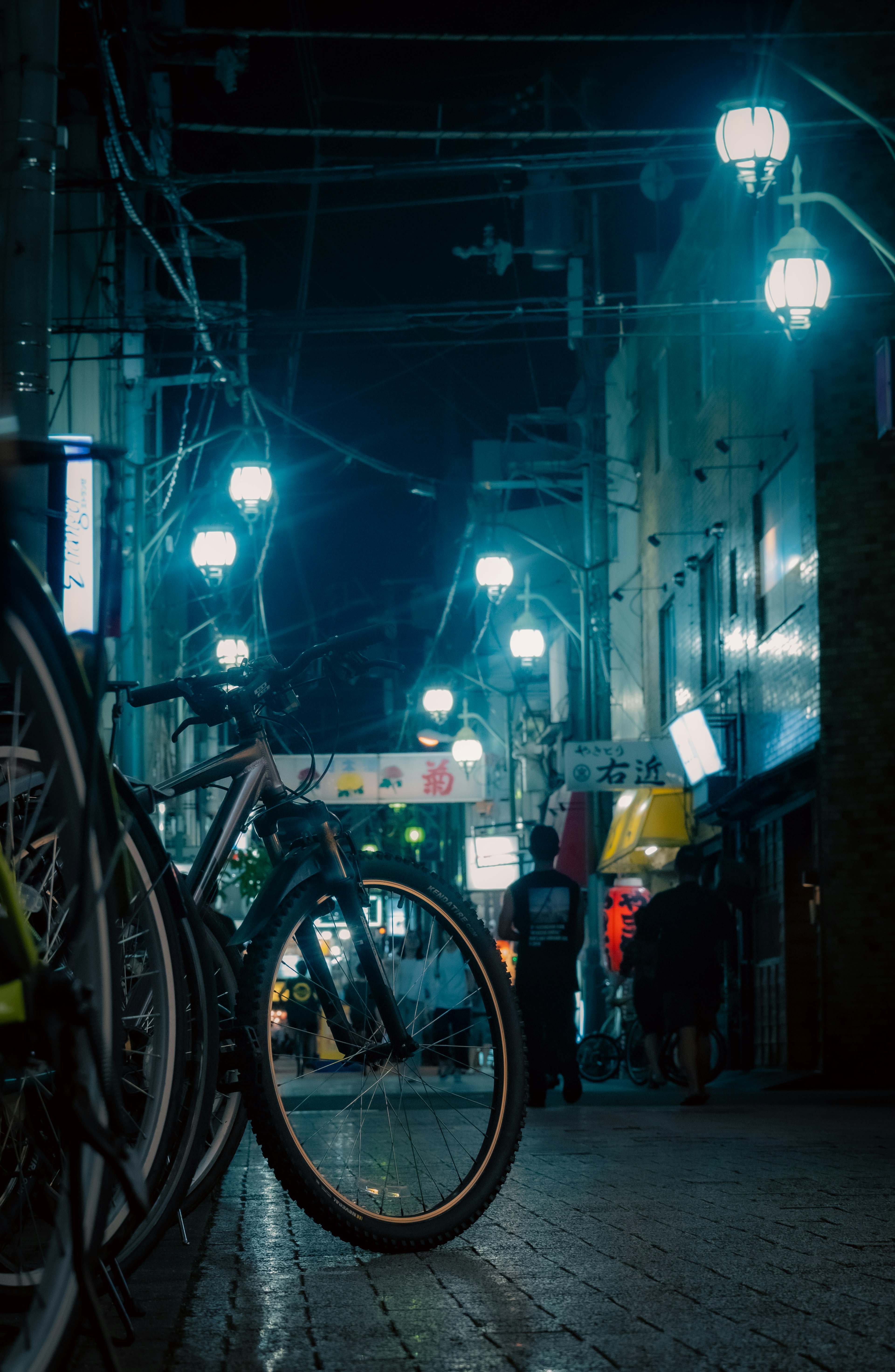 Vélo garé dans une rue nocturne avec des lampadaires bleus