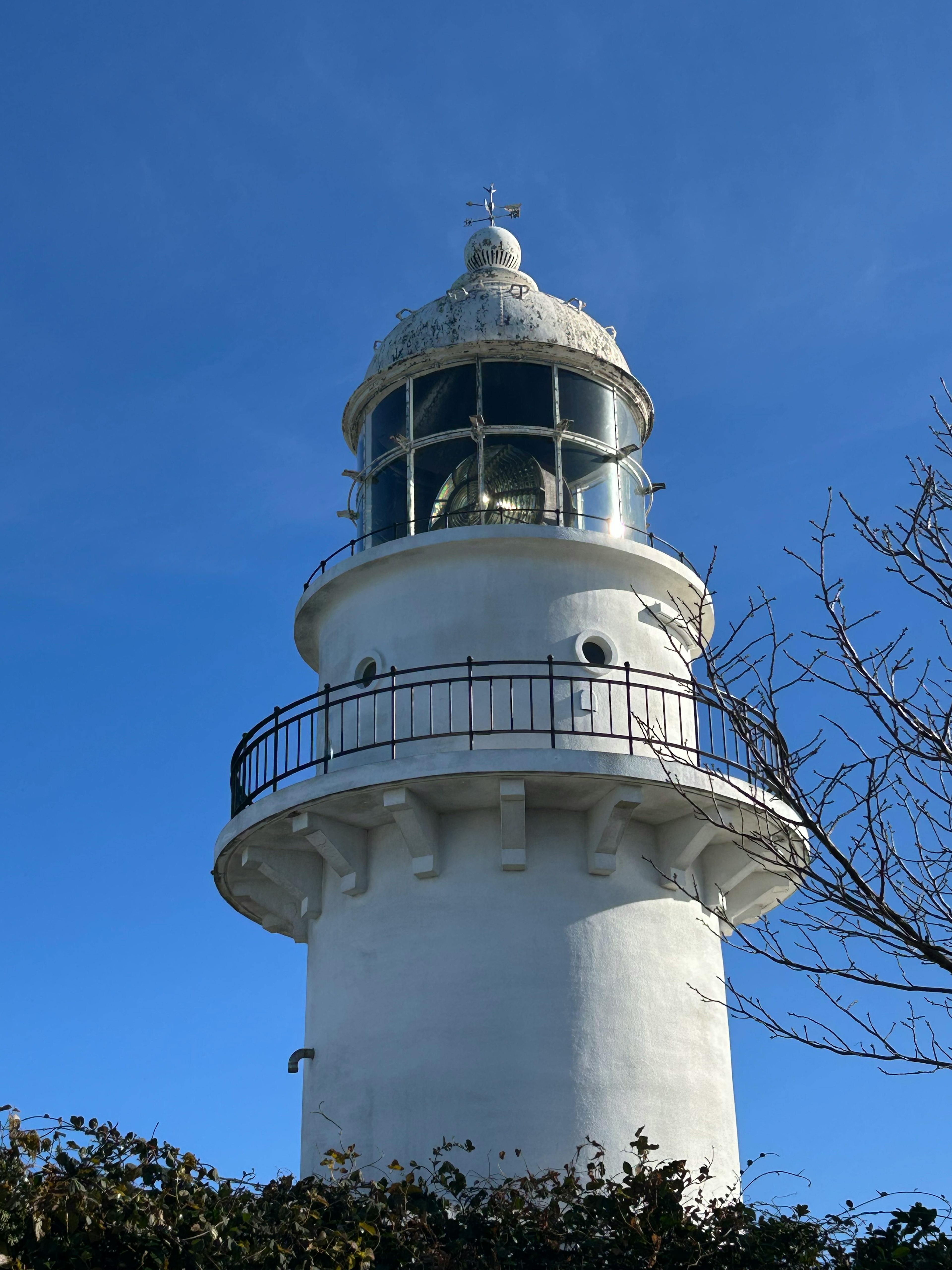 Weißer Leuchtturm steht unter blauem Himmel