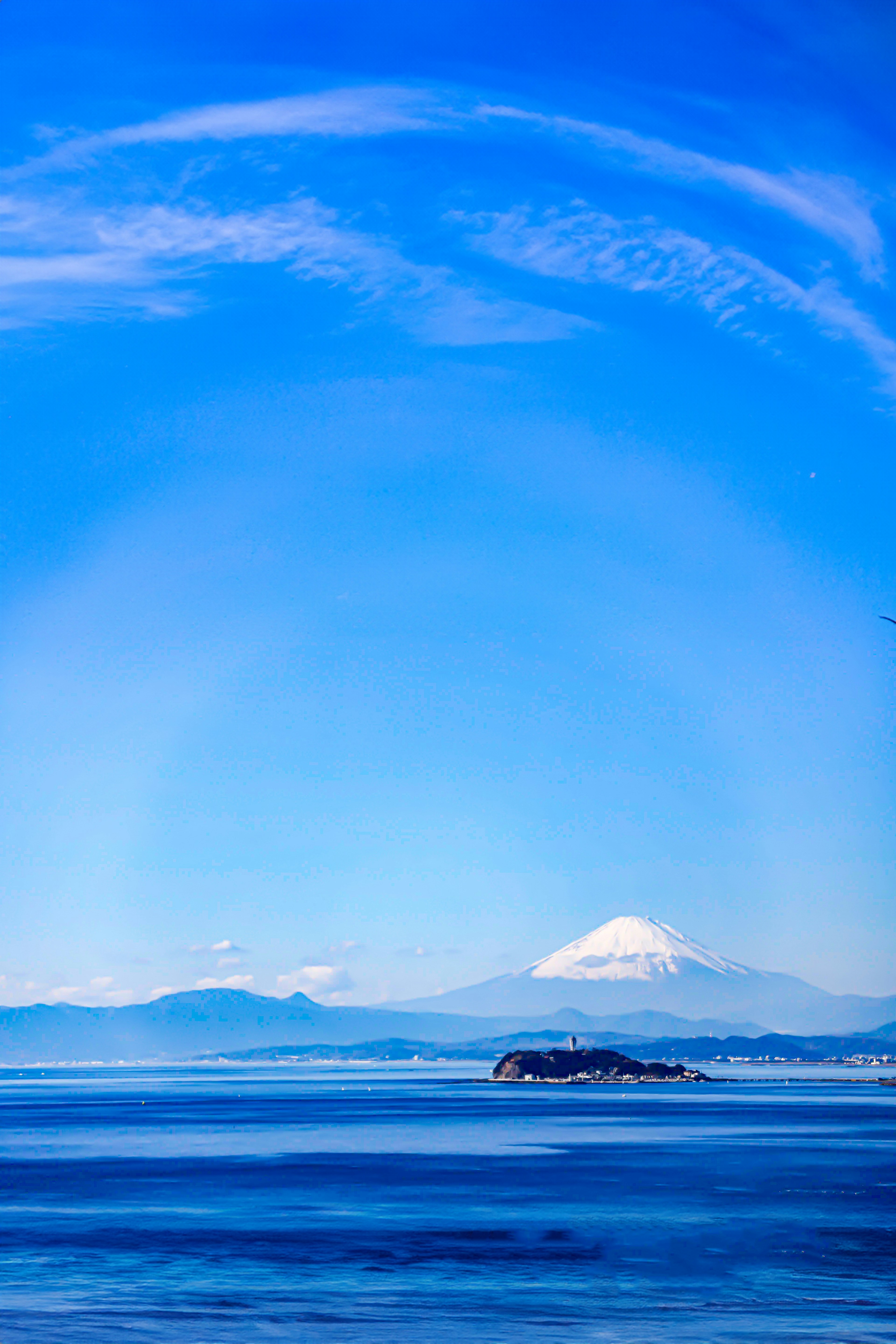 Clear blue sky with snow-capped mountains in the background