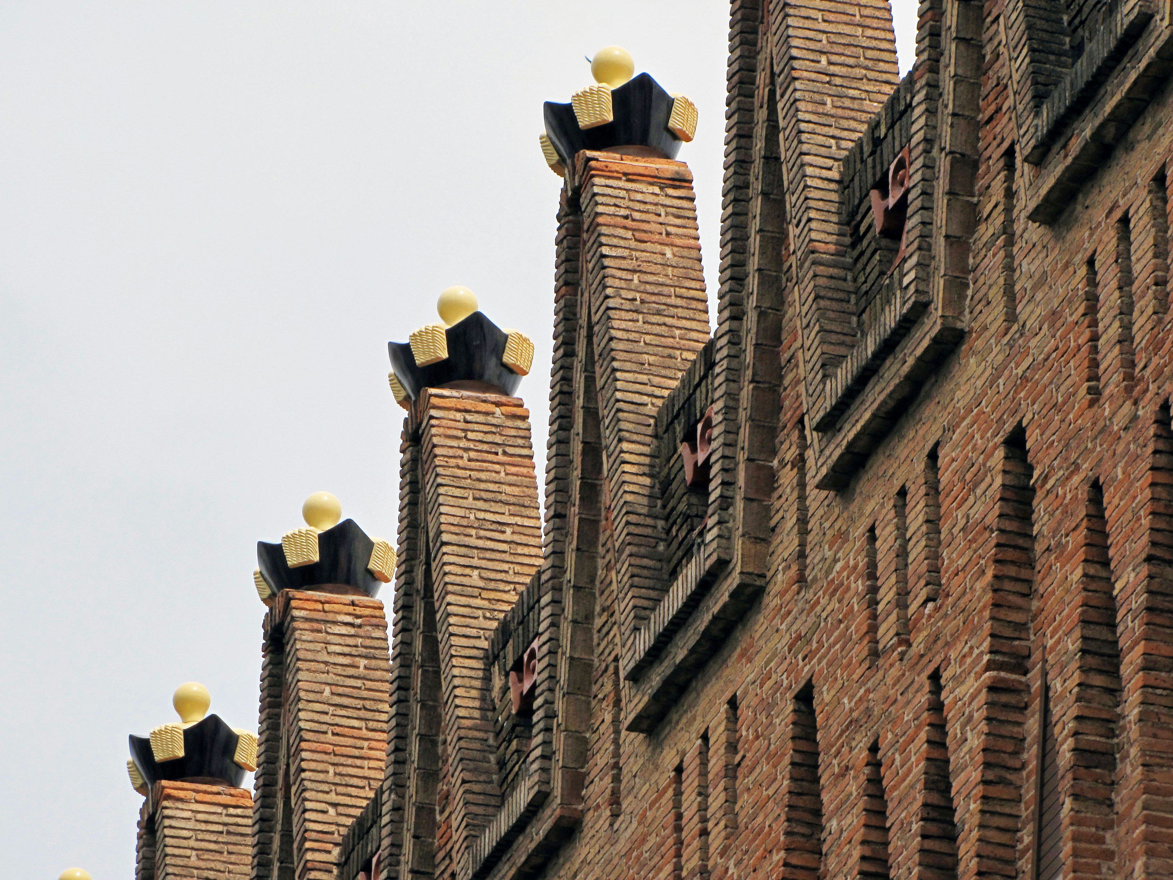 Row of yellow-topped towers on a brick building roof