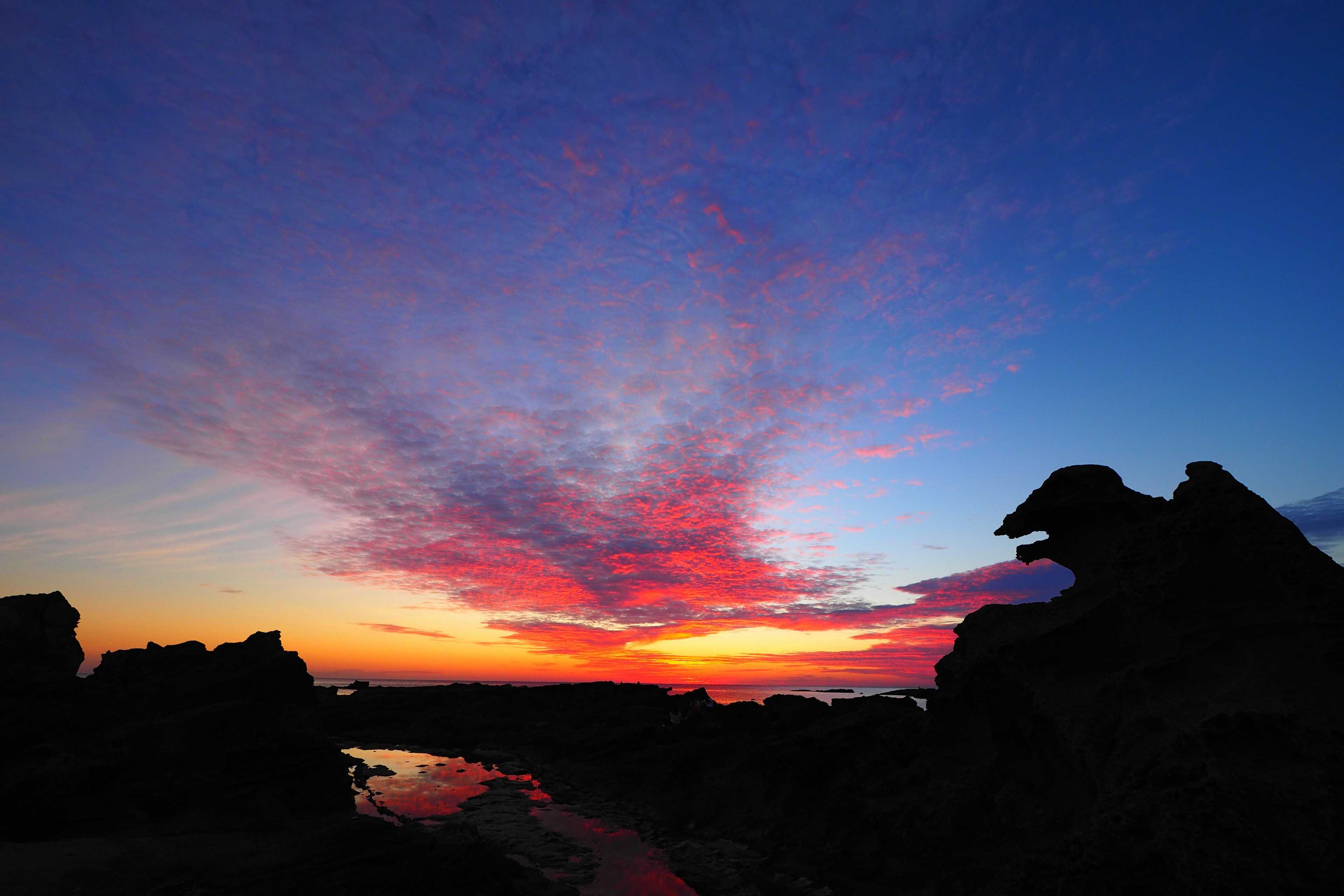 Sonnenuntergangshimmel mit silhouettierten Felsen