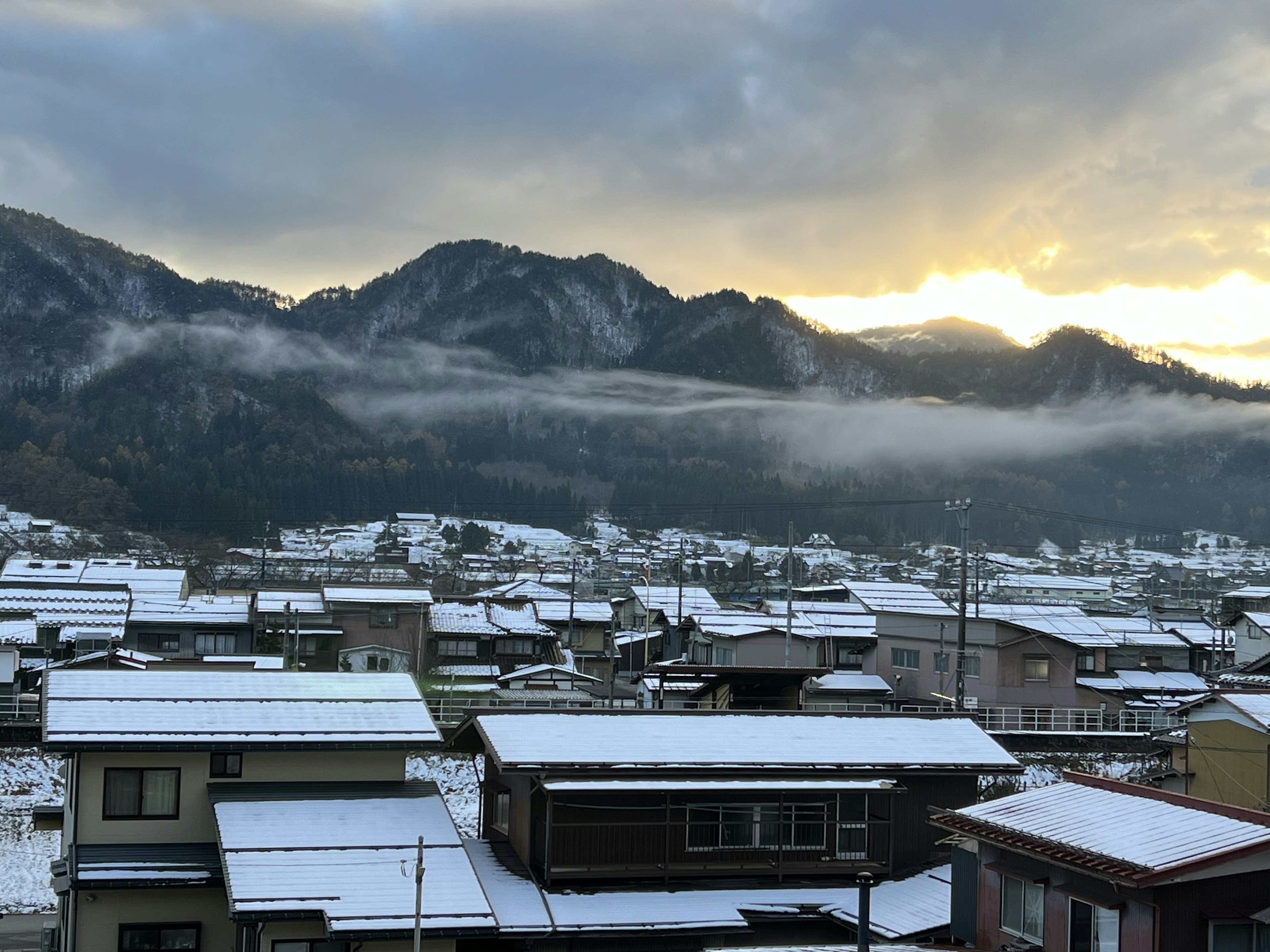 Città coperta di neve con montagne sullo sfondo