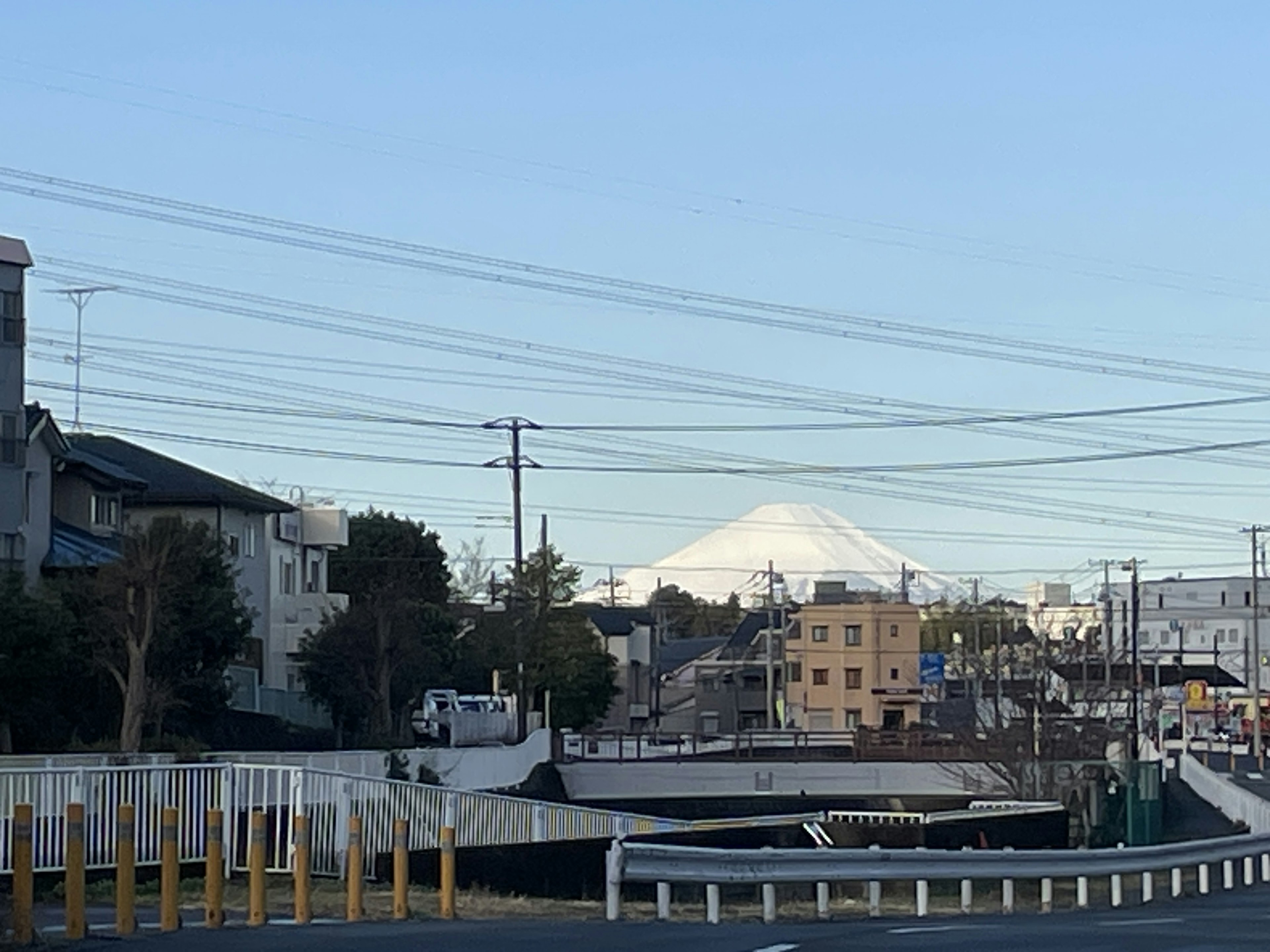 Paesaggio urbano con il monte Fuji sullo sfondo e linee elettriche