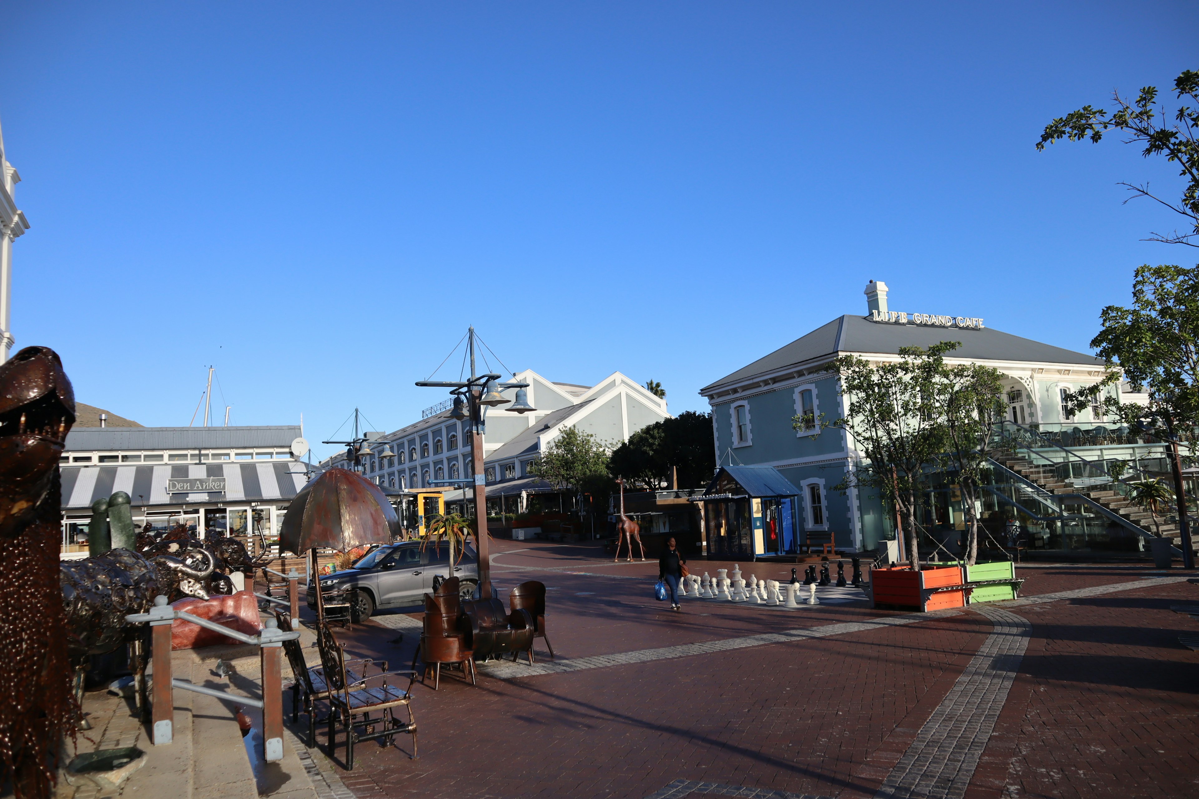 Open square featuring art and sculptures under a clear blue sky