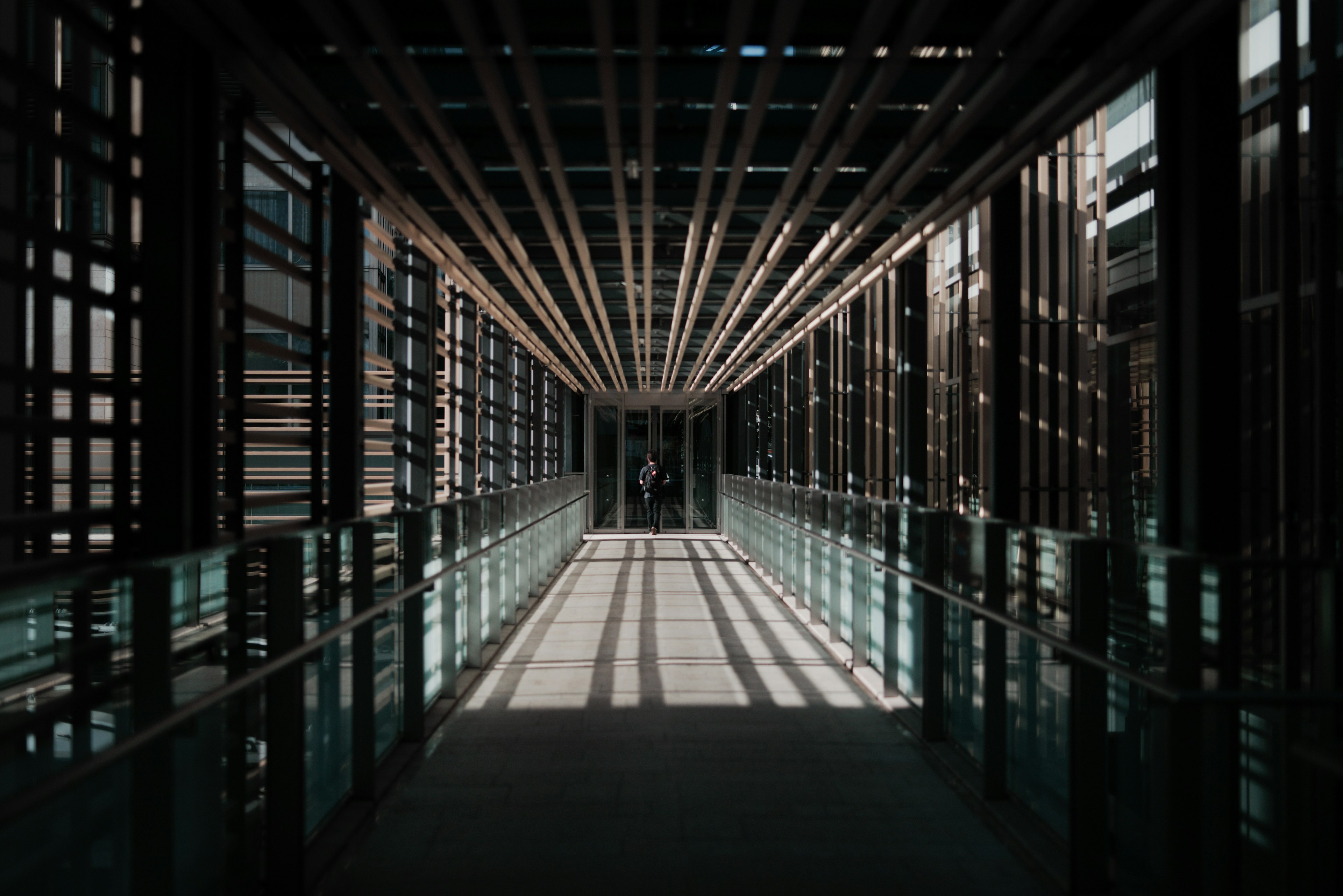 Interior of a modern corridor featuring wooden beams and glass railings