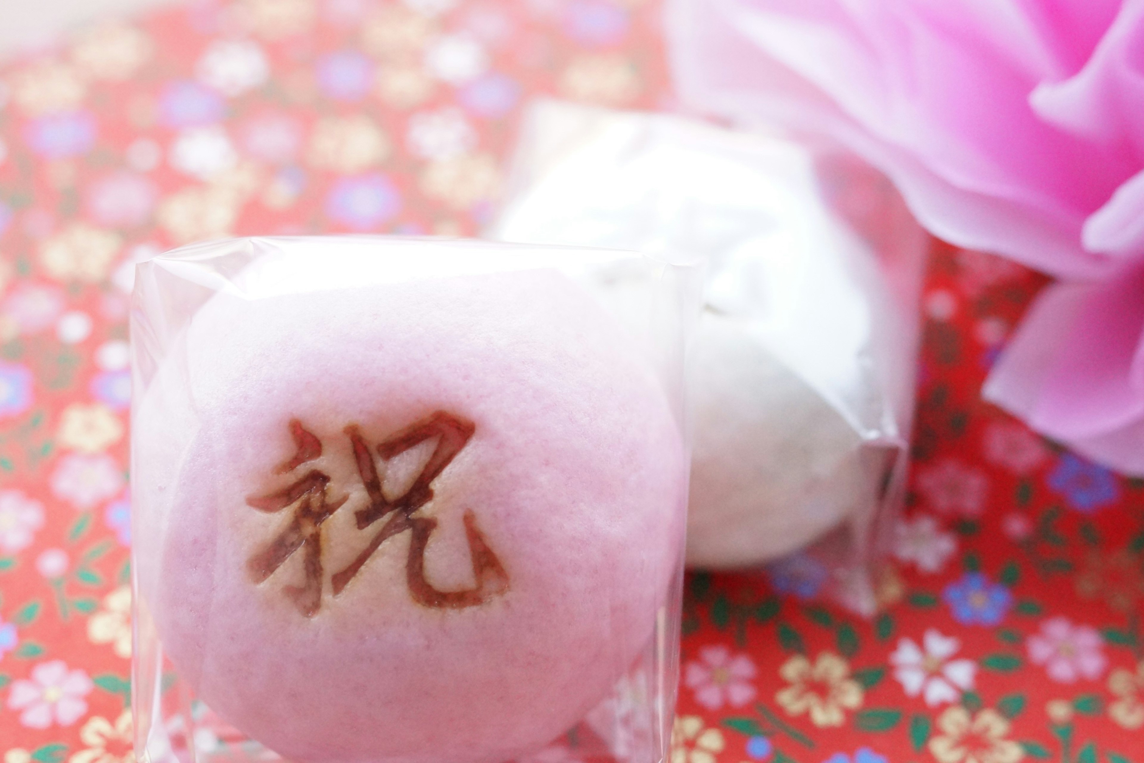 Ensemble de douceurs japonaises sur un fond floral coloré manju rose et blanc avec le caractère pour célébration