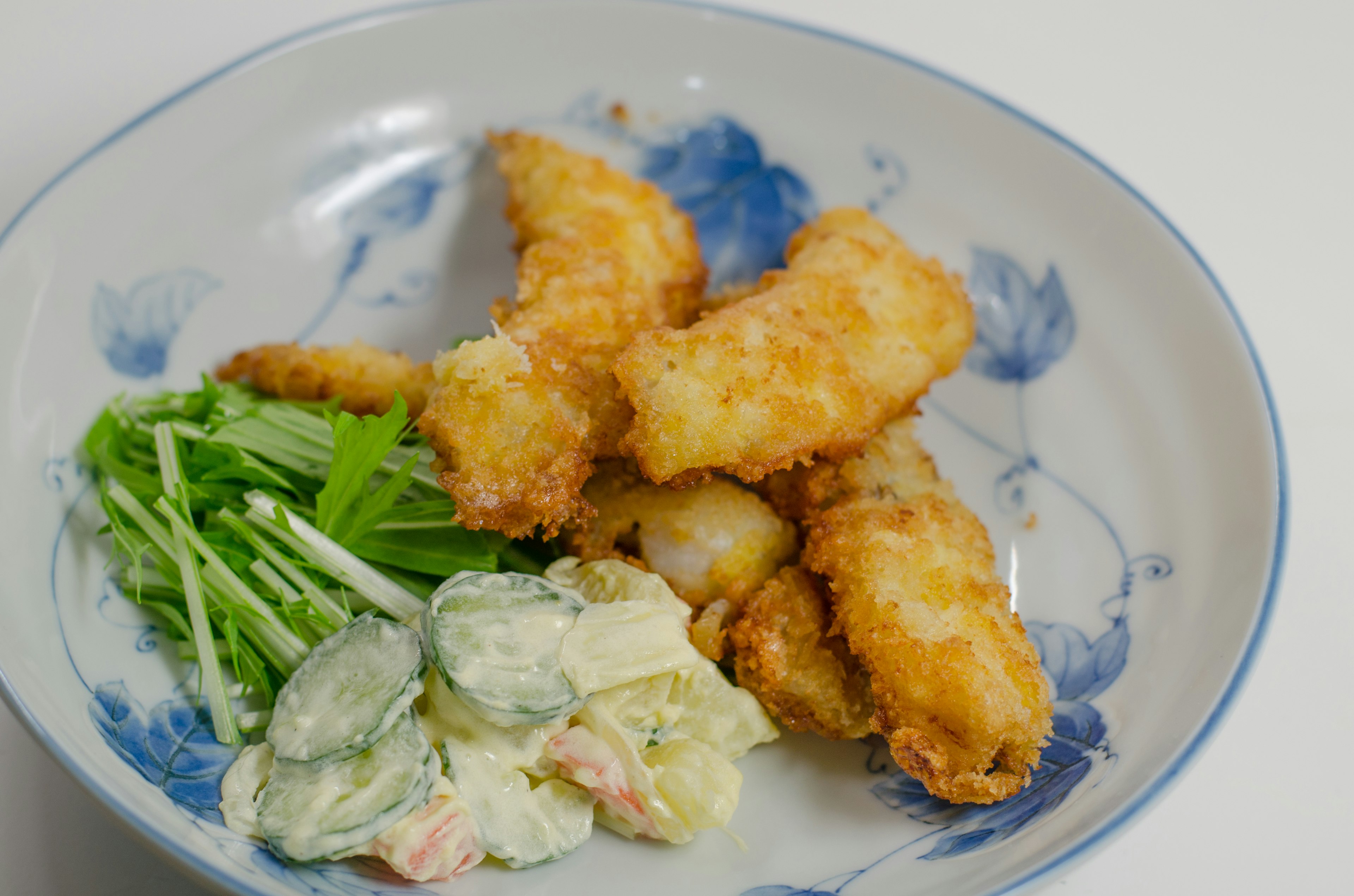 Fried white fish with salad on a decorative plate