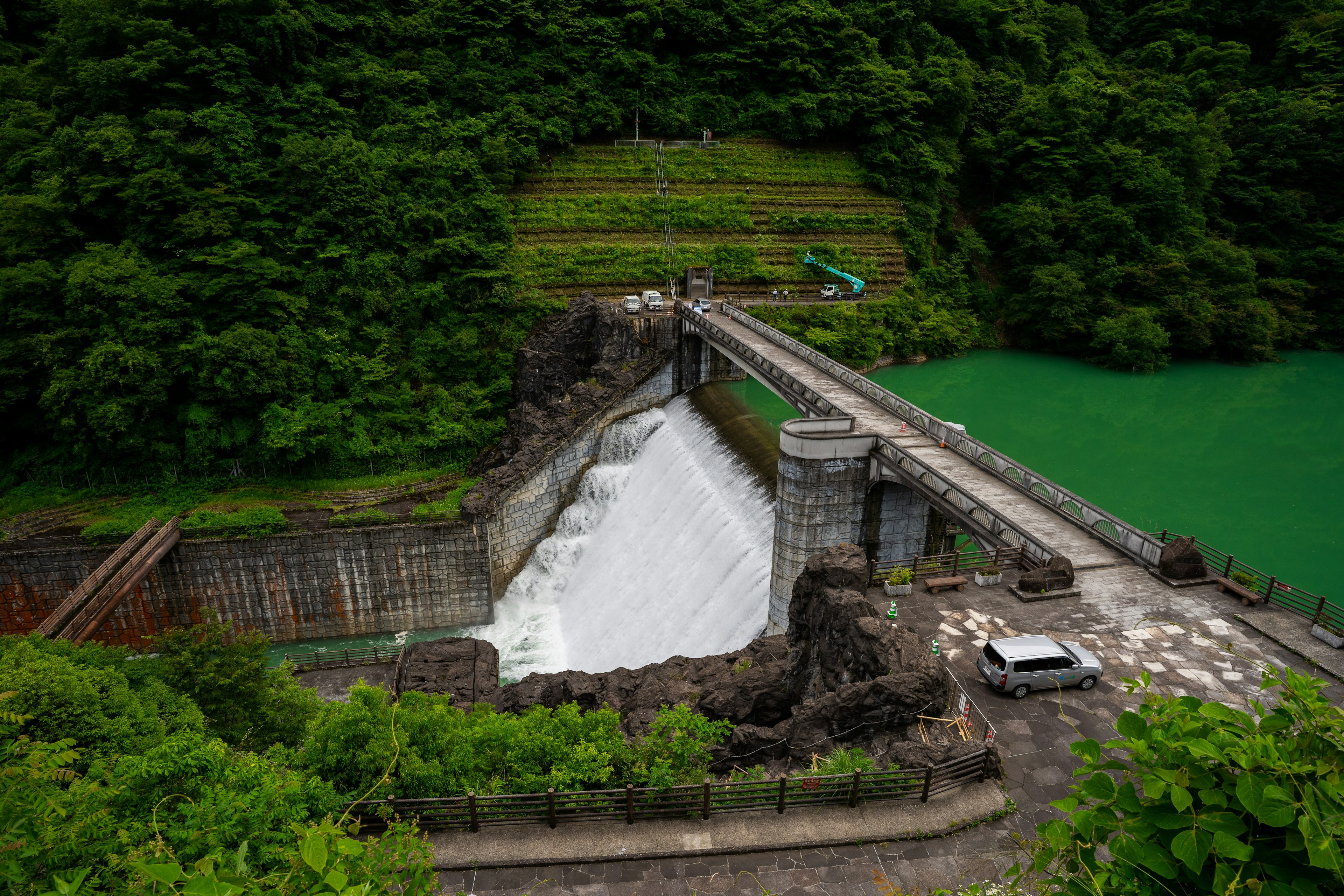 Barrage entouré de verdure luxuriante avec de l'eau qui coule