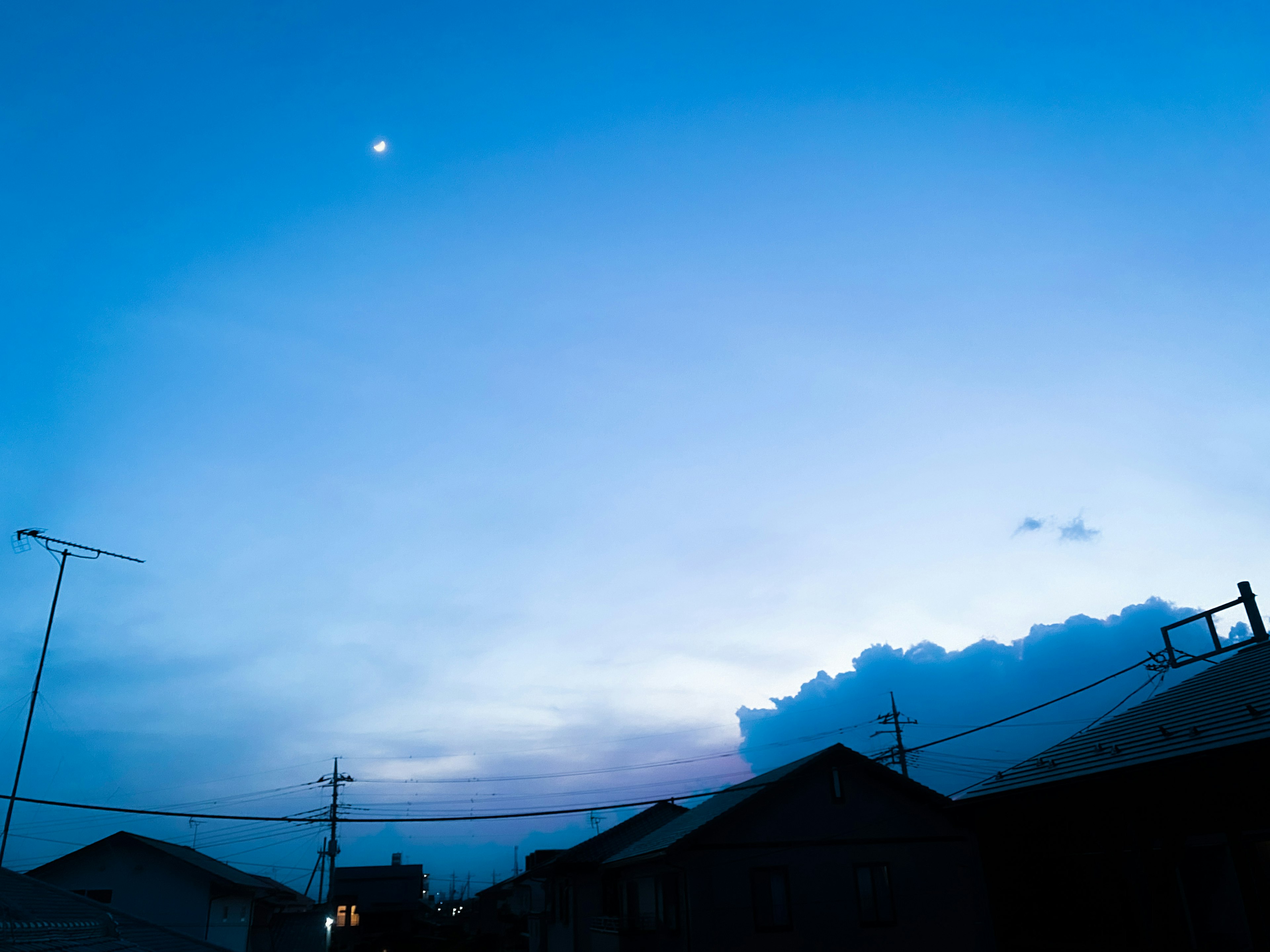 青い空と月が見える夕暮れの風景