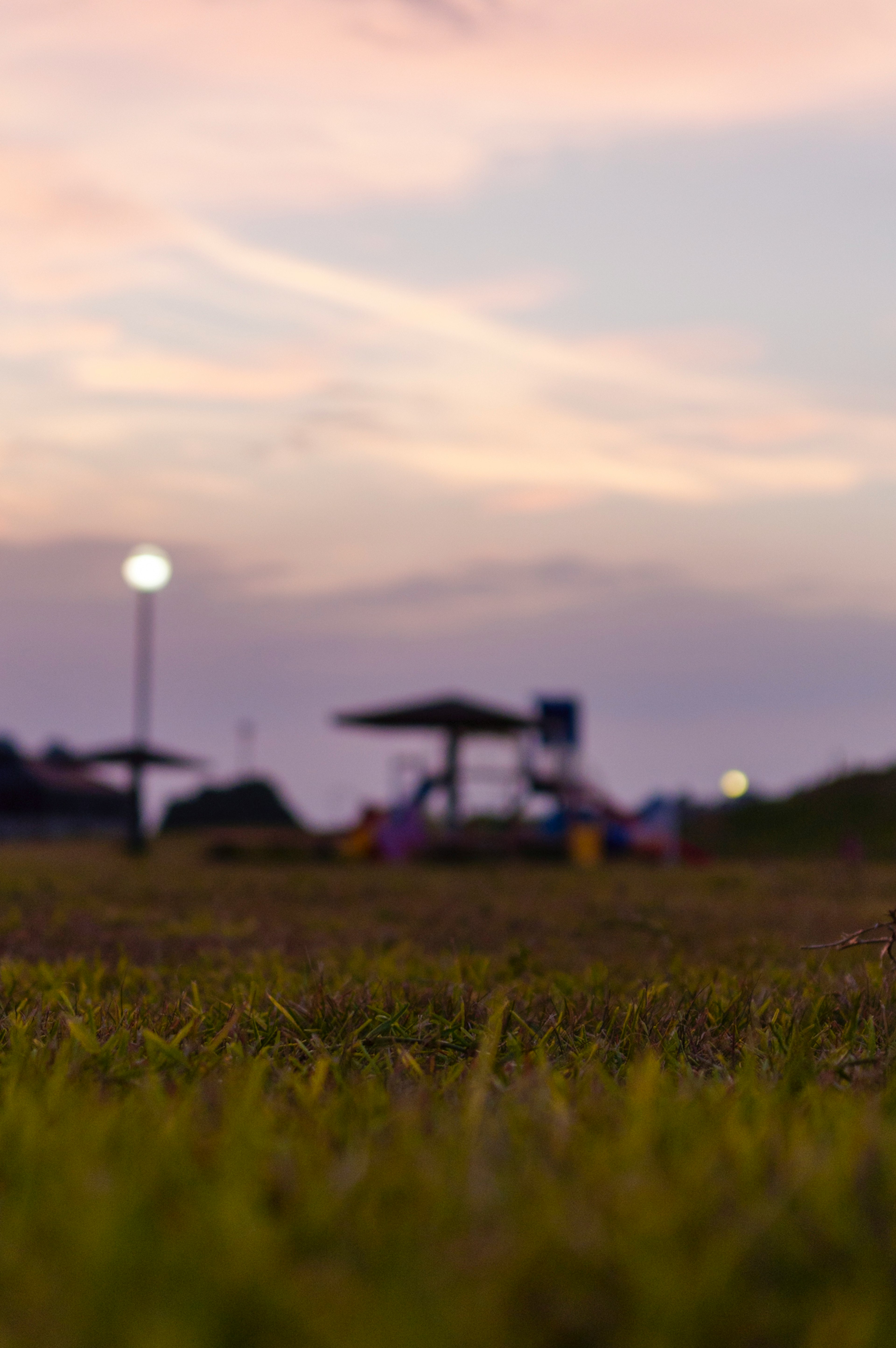 Parkszene mit Spielplatz und Sonnenuntergangshimmel