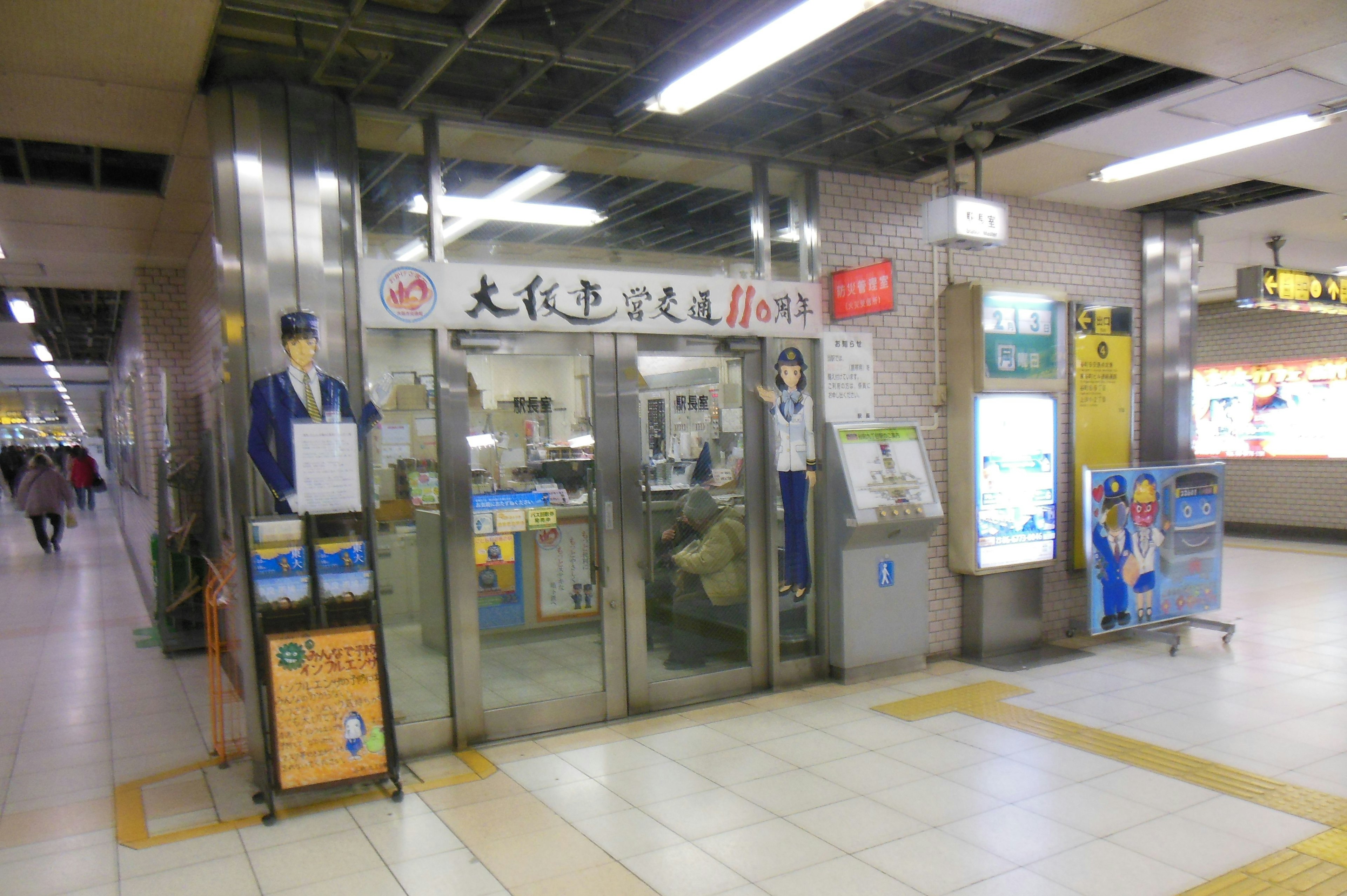 Entrance to a train station with glass doors and informational signage