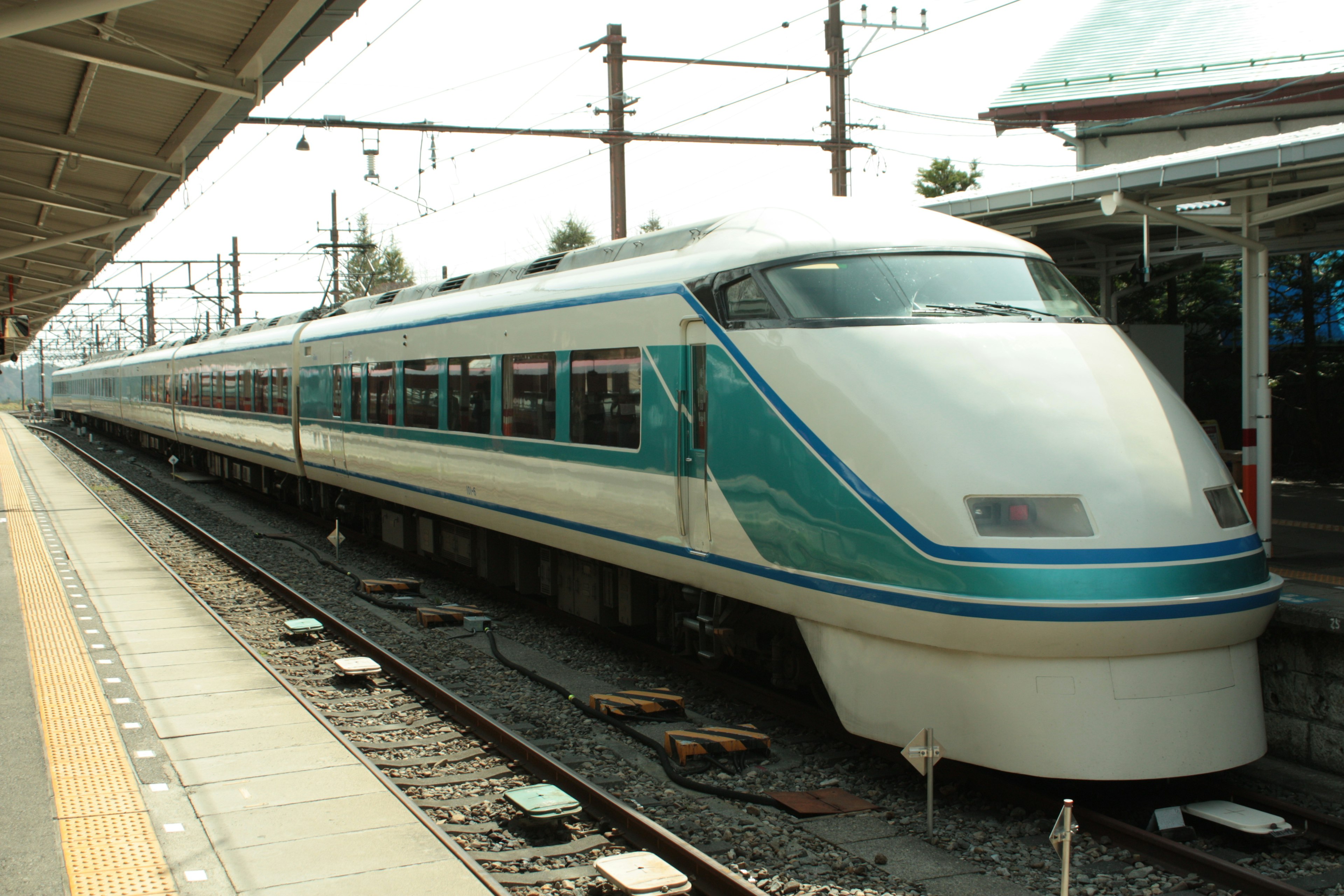 Kereta ekspres dengan garis biru diparkir di stasiun