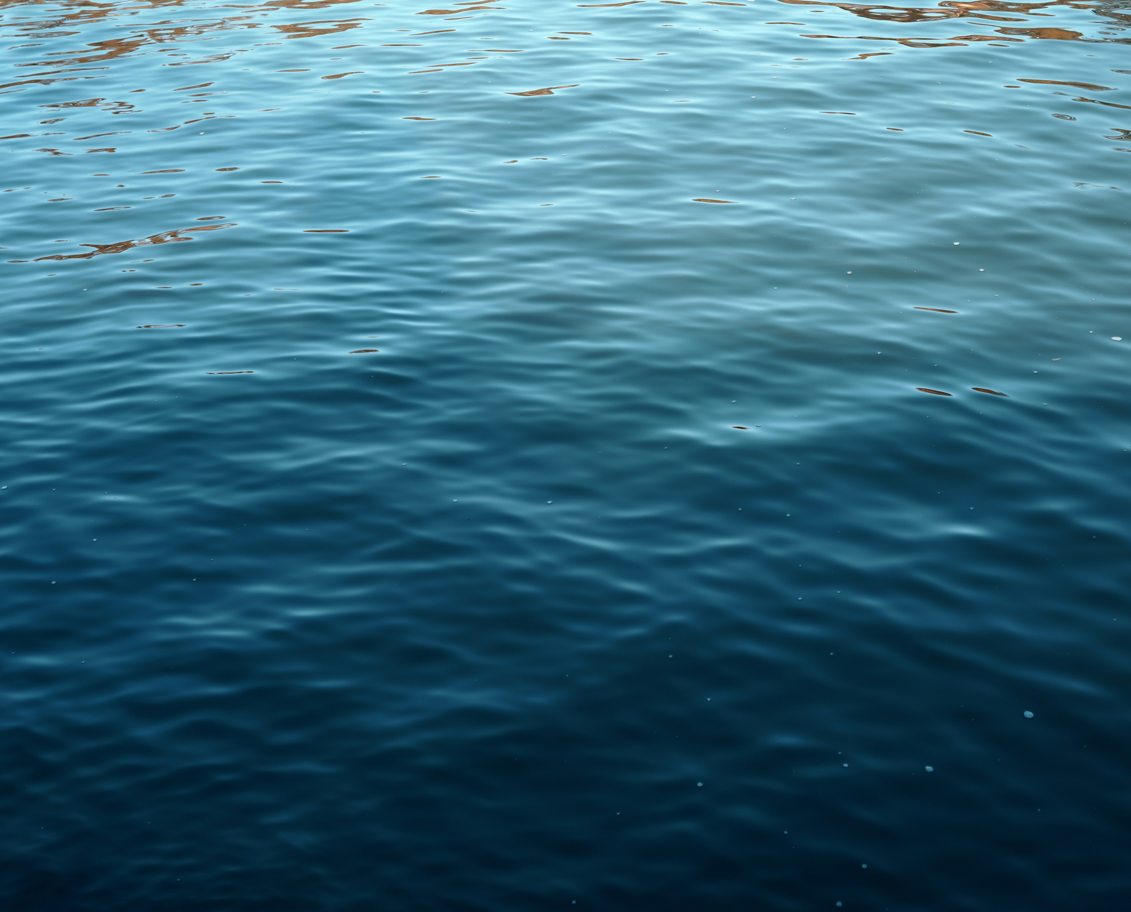 Superficie de agua tranquila con suaves ondas y reflejos