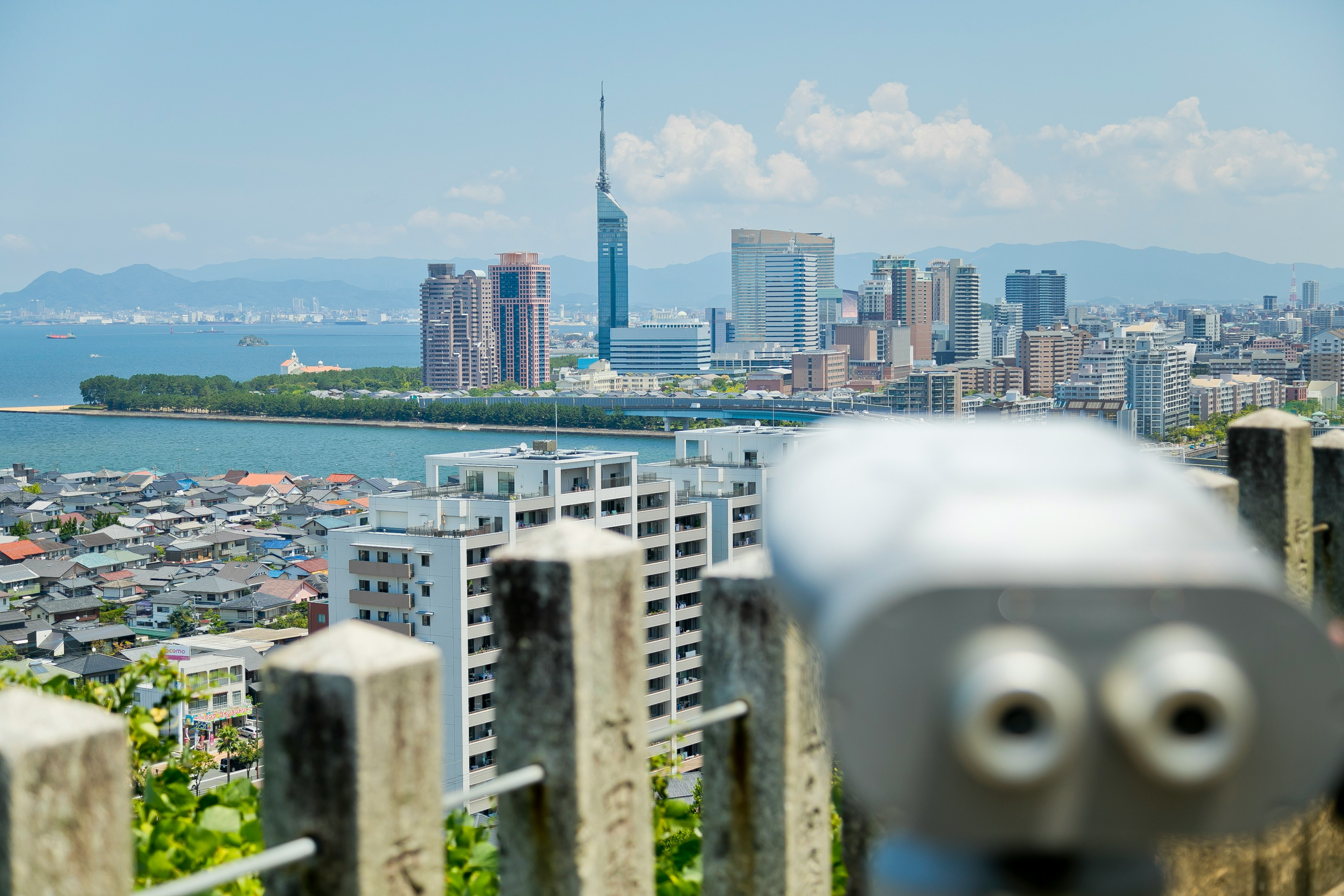 City skyline view overlooking the ocean with a telescope