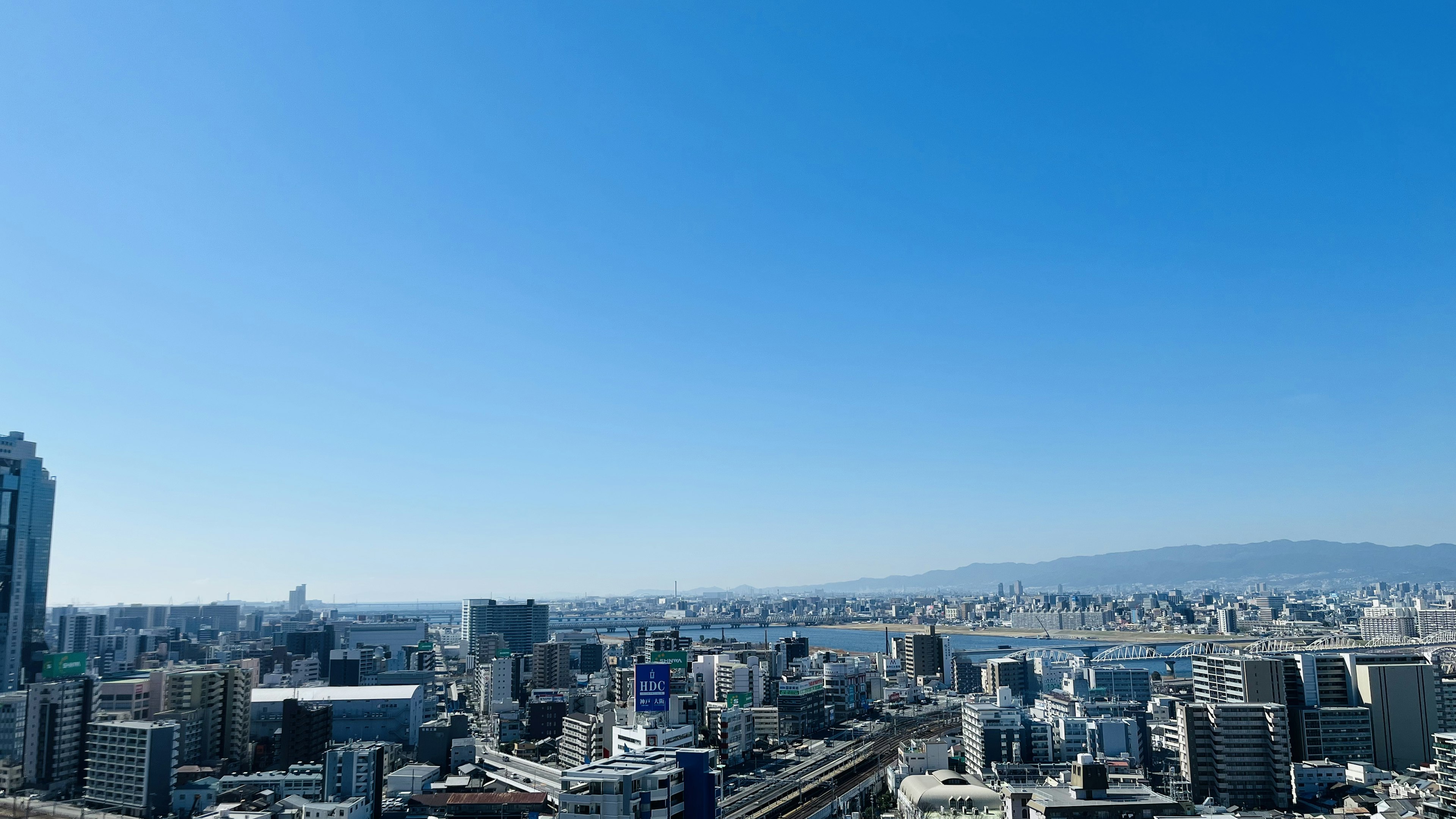 青空の下に広がる都市のパノラマビュー高層ビルが立ち並ぶ