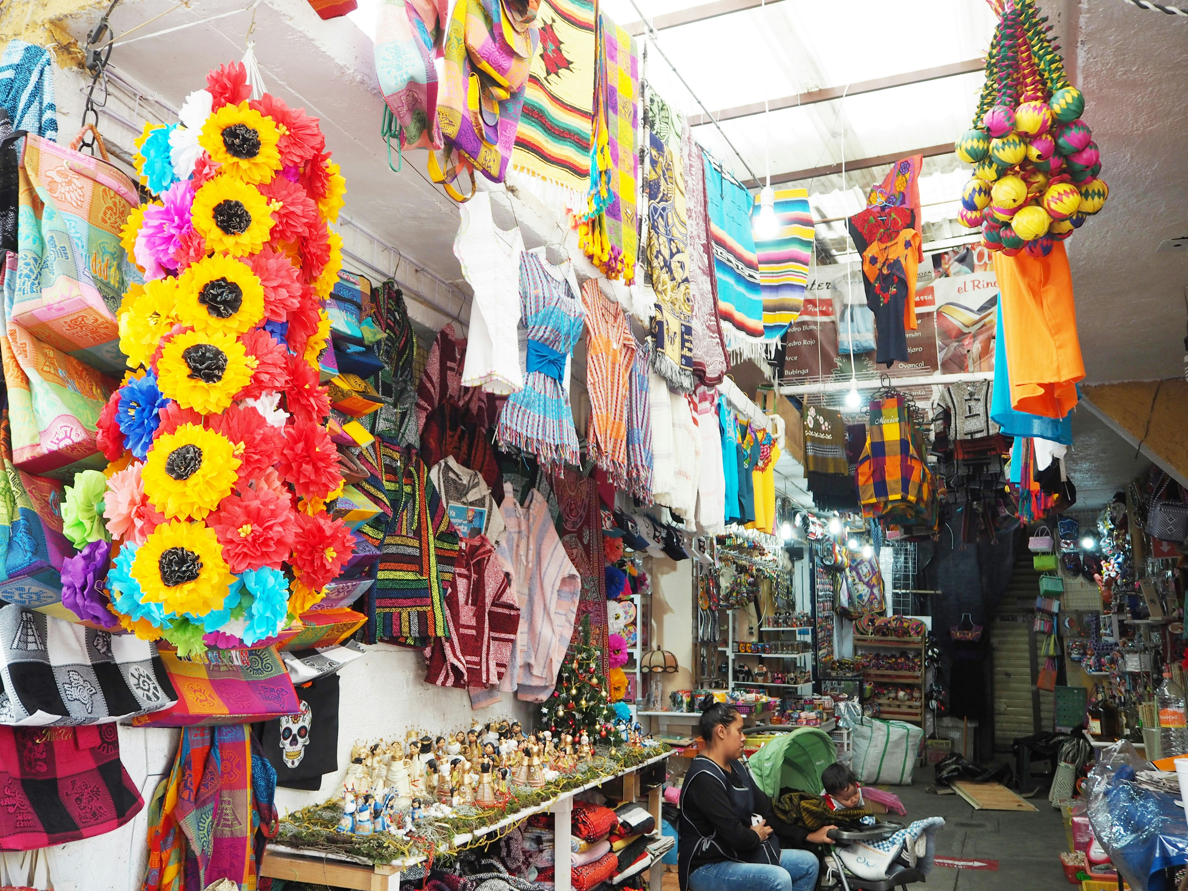 Interno di un mercato messicano vibrante pieno di tessuti colorati e decorazioni