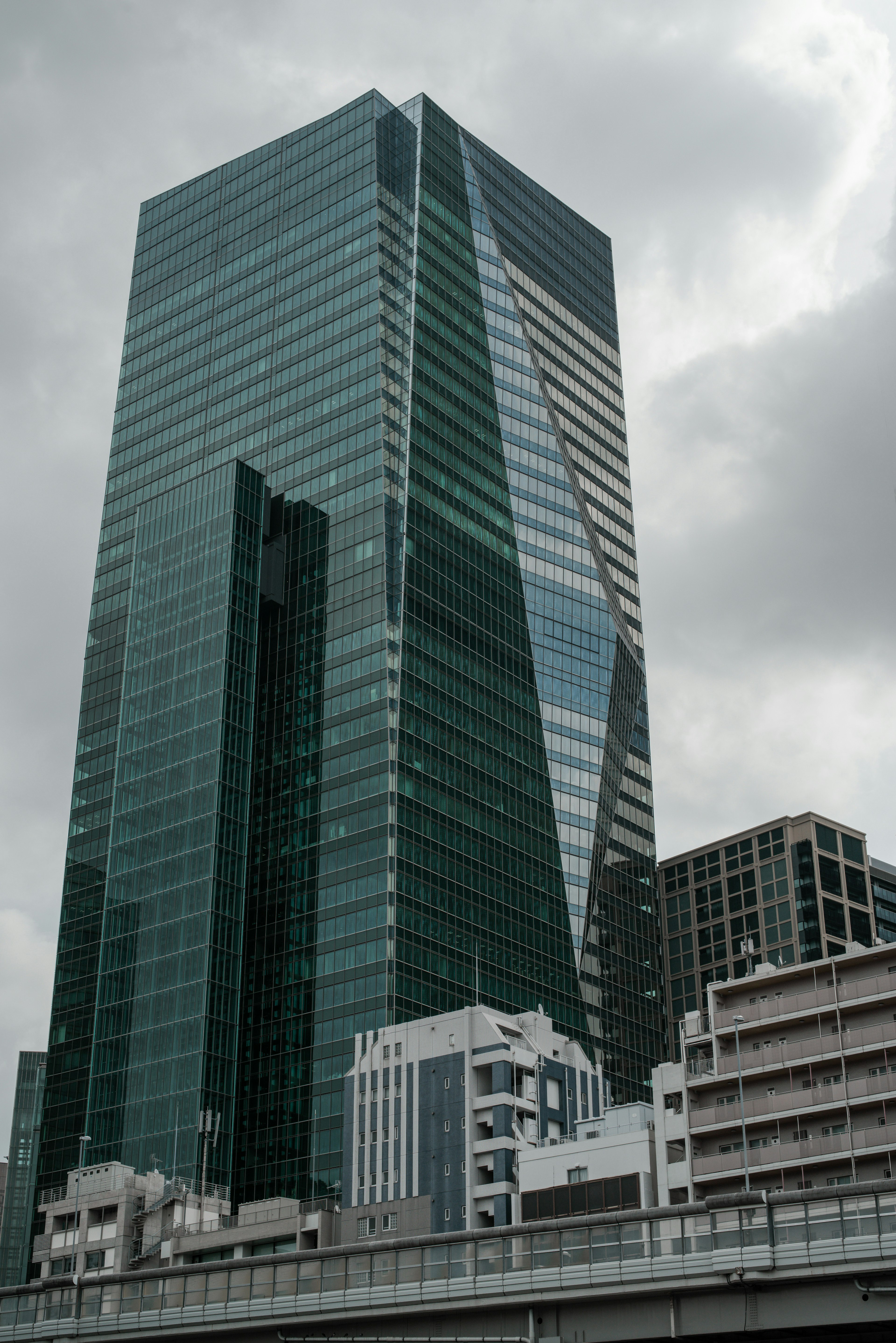 Un alto edificio de vidrio bajo un cielo nublado