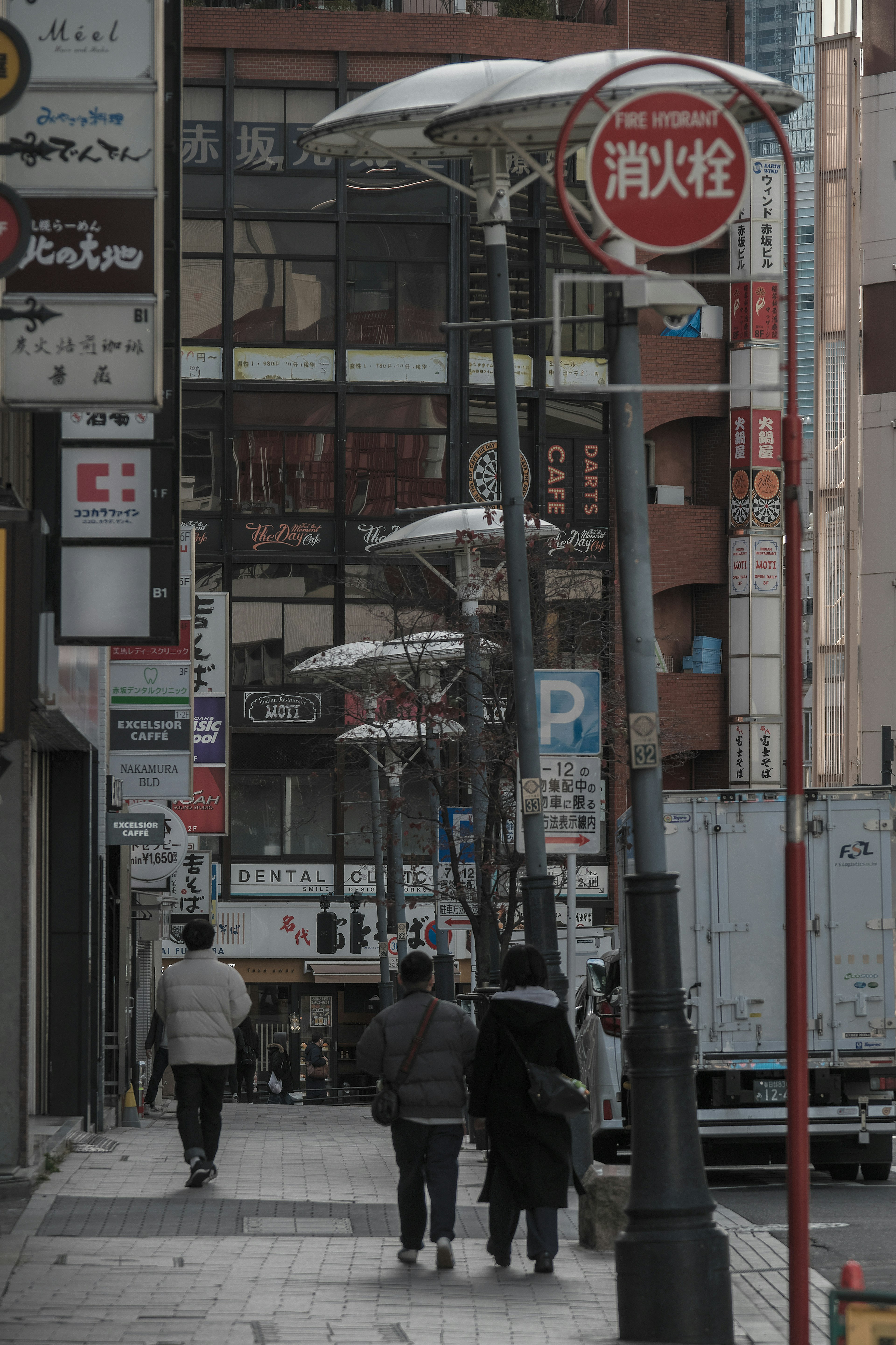 People walking on a street with streetlights and storefronts