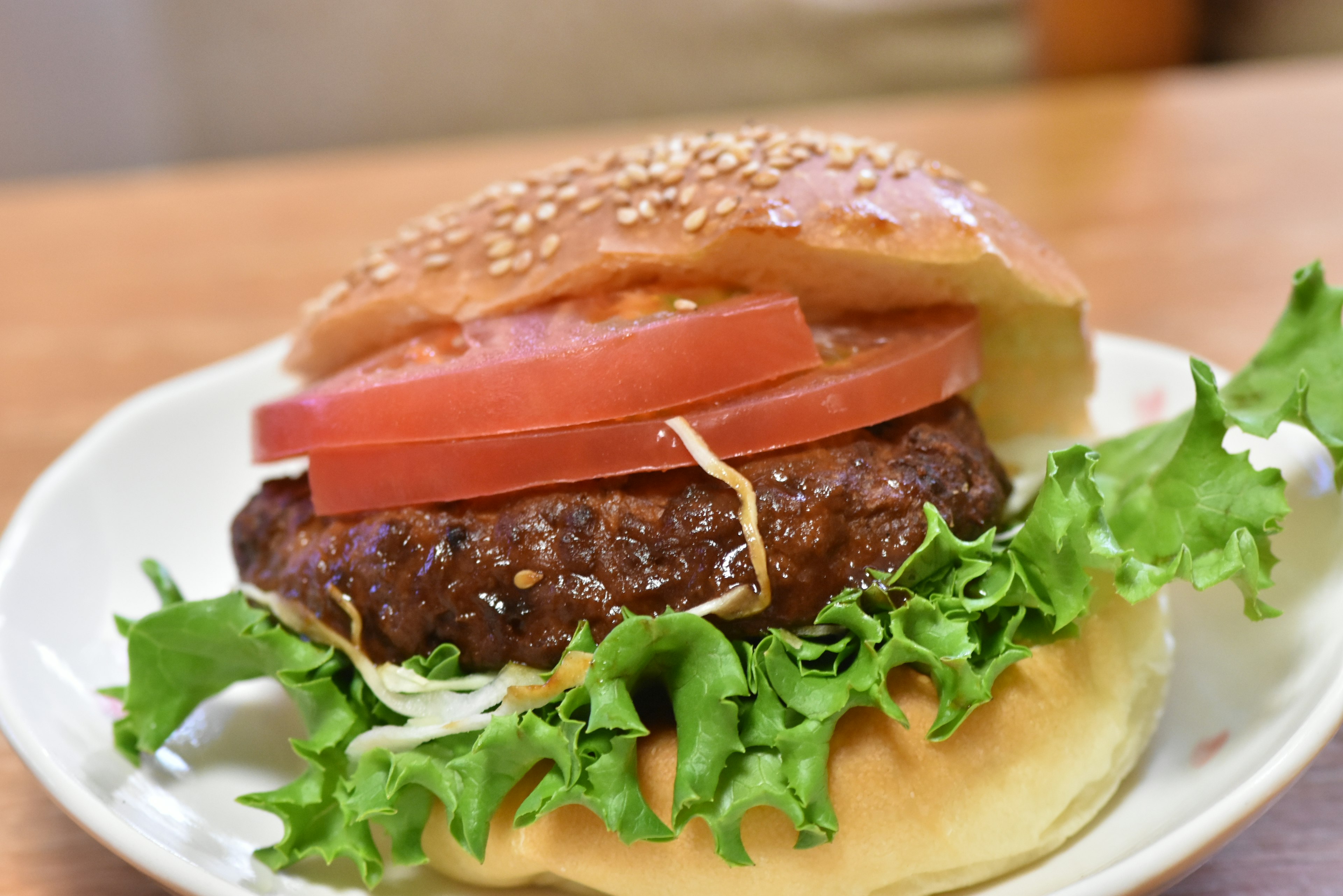 Un hamburger con lattuga fresca e pomodoro su un panino ai semi di sesamo