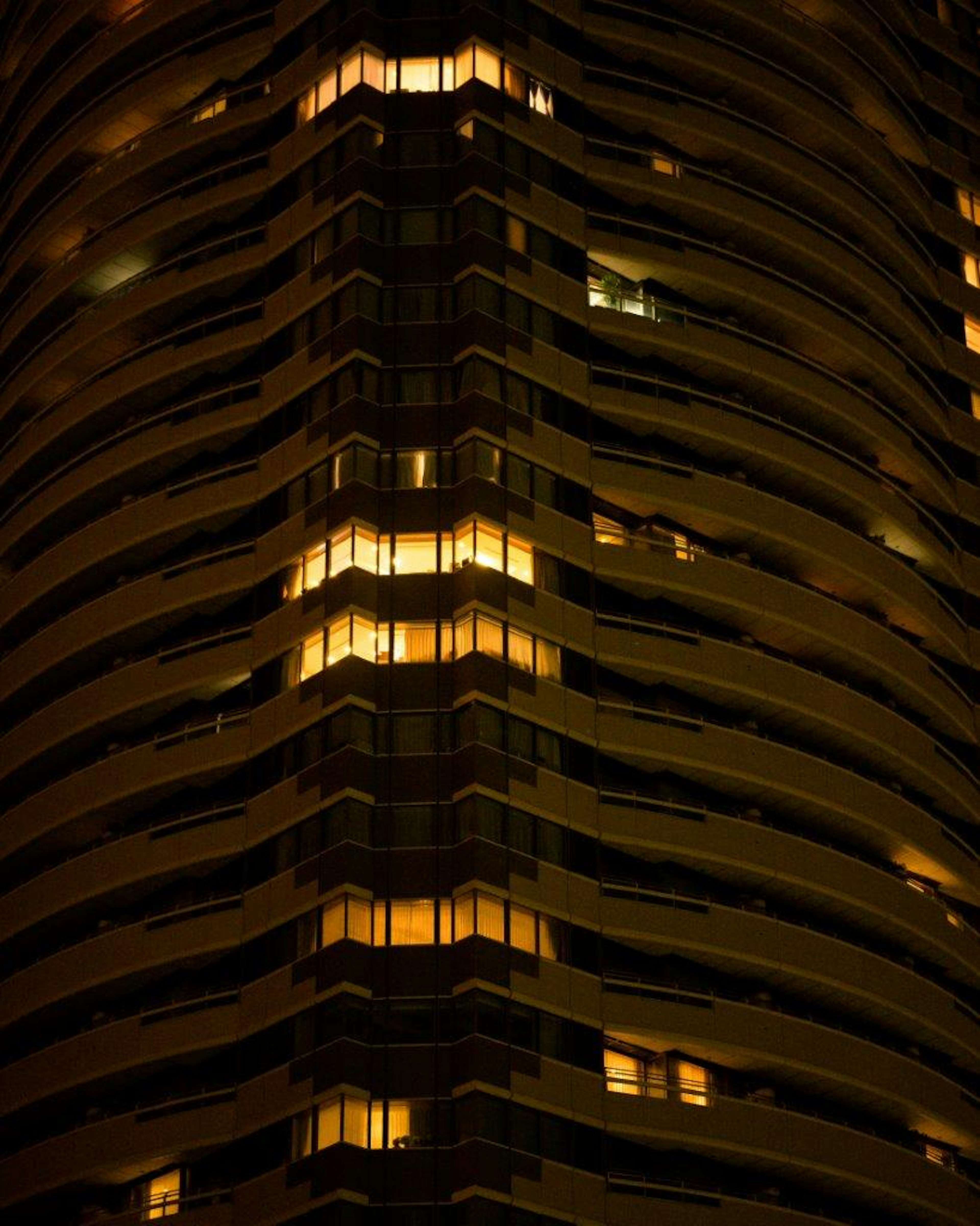 Vista nocturna de un rascacielos con ventanas iluminadas