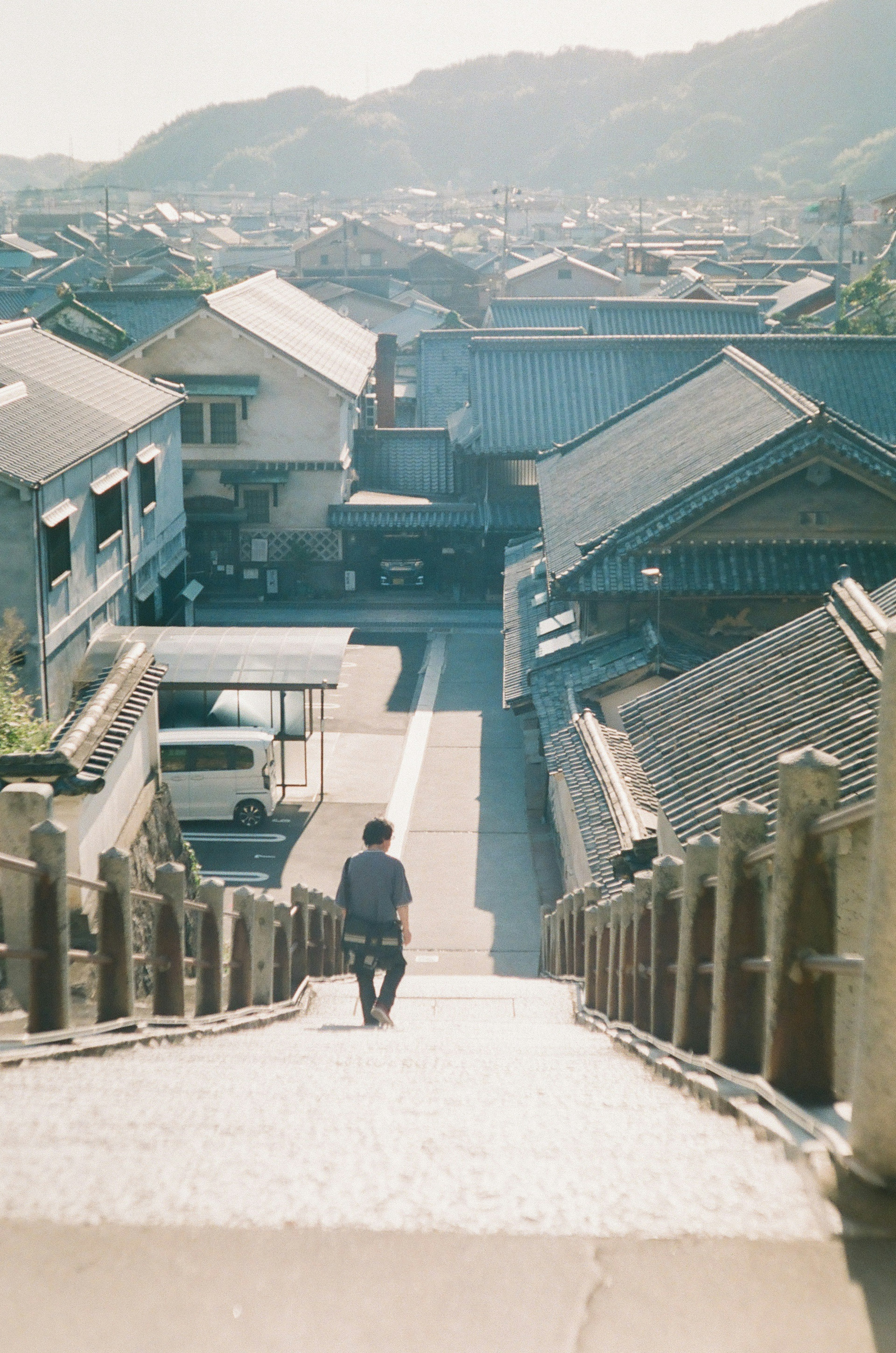 階段を下る人物と伝統的な建物が見える風景