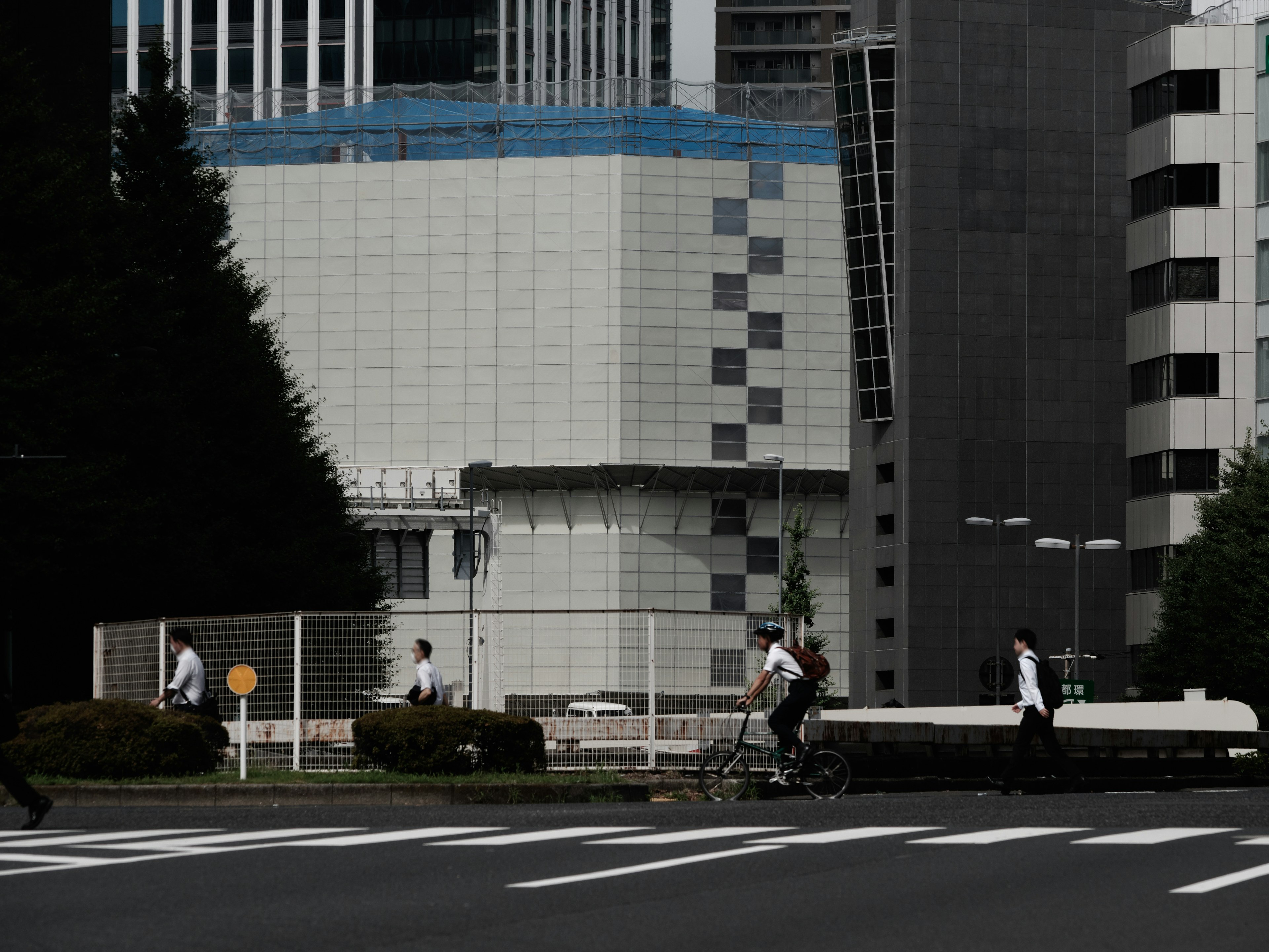 ビジネスマンが街を歩くシーンと自転車を漕ぐ人がいる都市風景