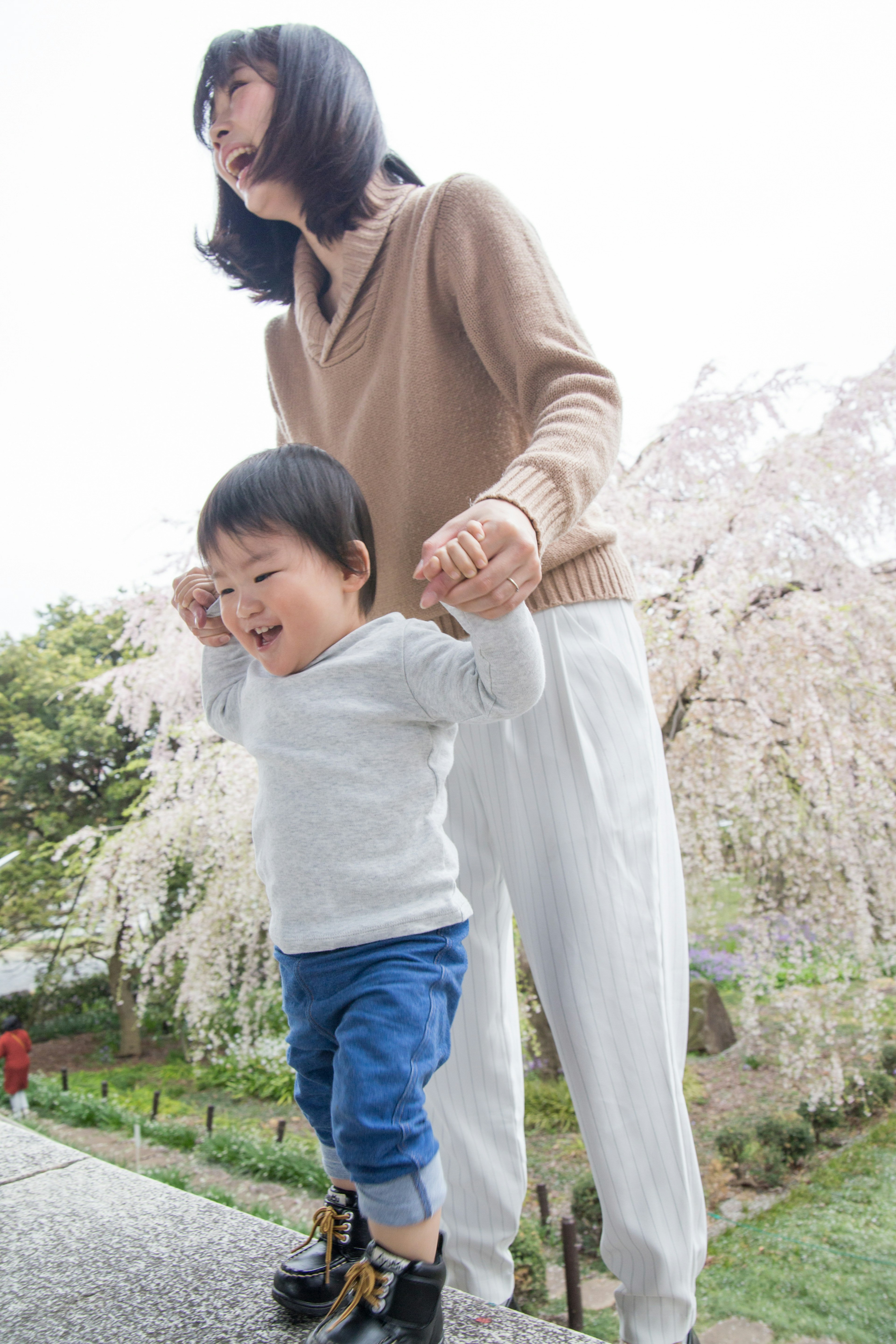 Mère et enfant jouant sous des cerisiers en fleurs