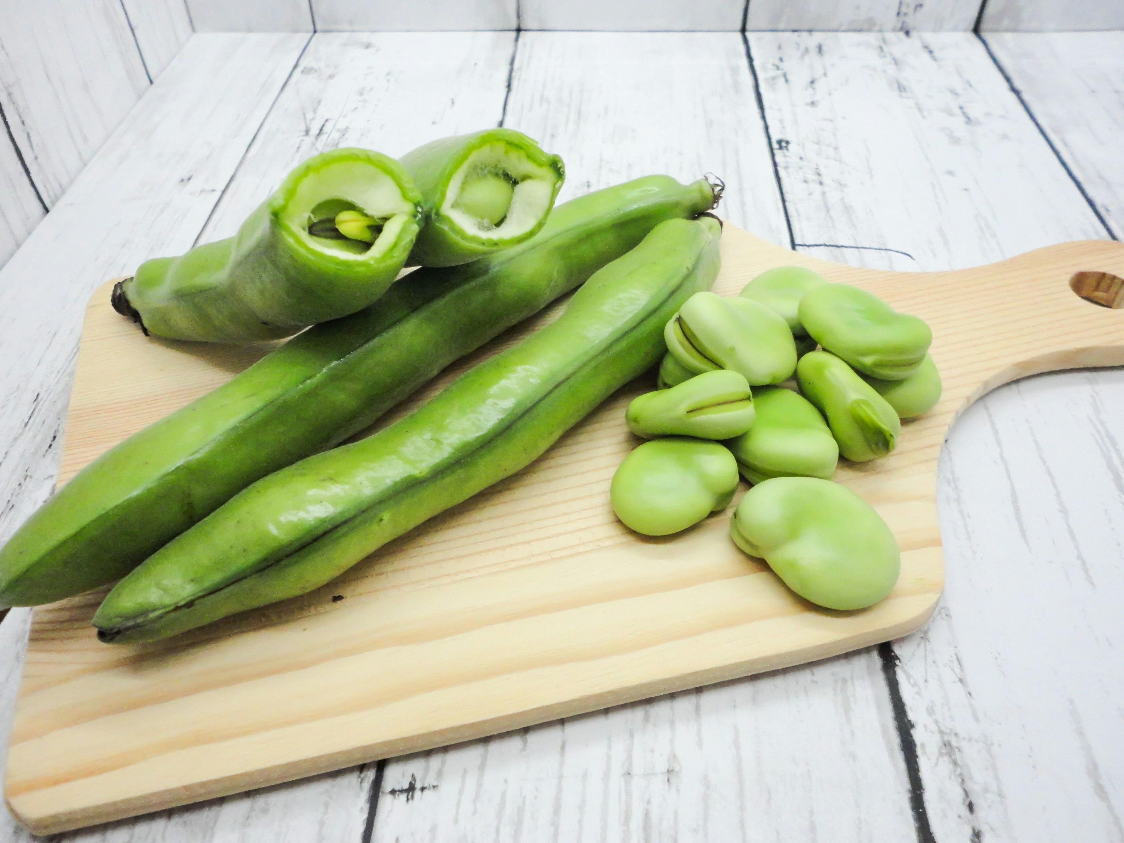 Kacang hijau dan polong di atas papan pemotong kayu