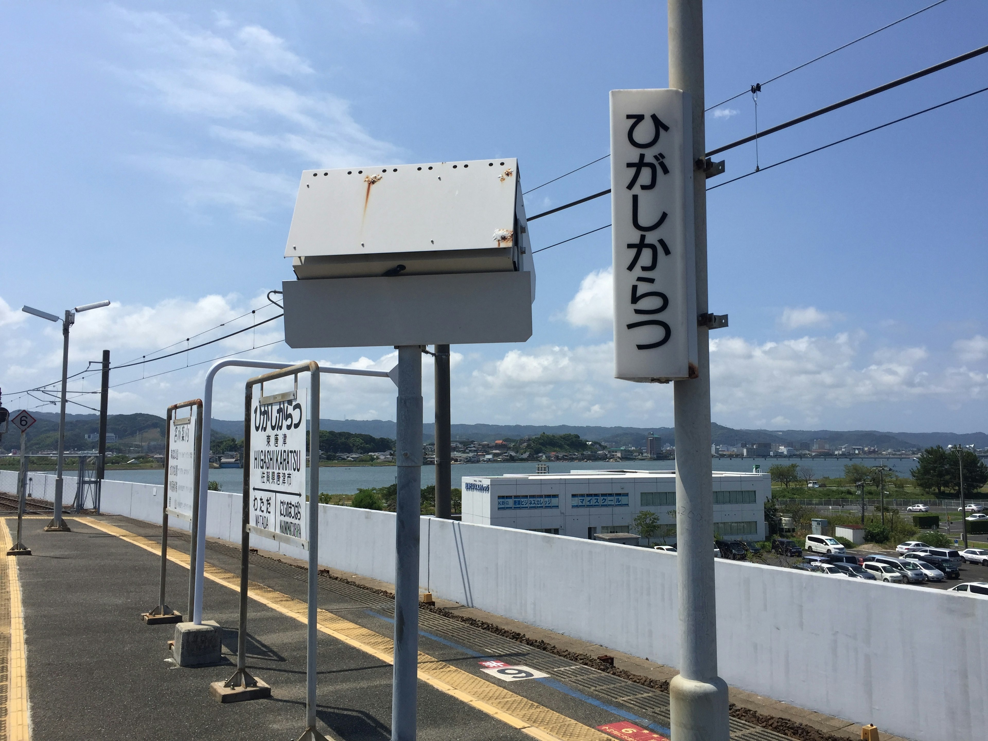 Platform stasiun dengan tanda dan pemandangan di bawah langit biru