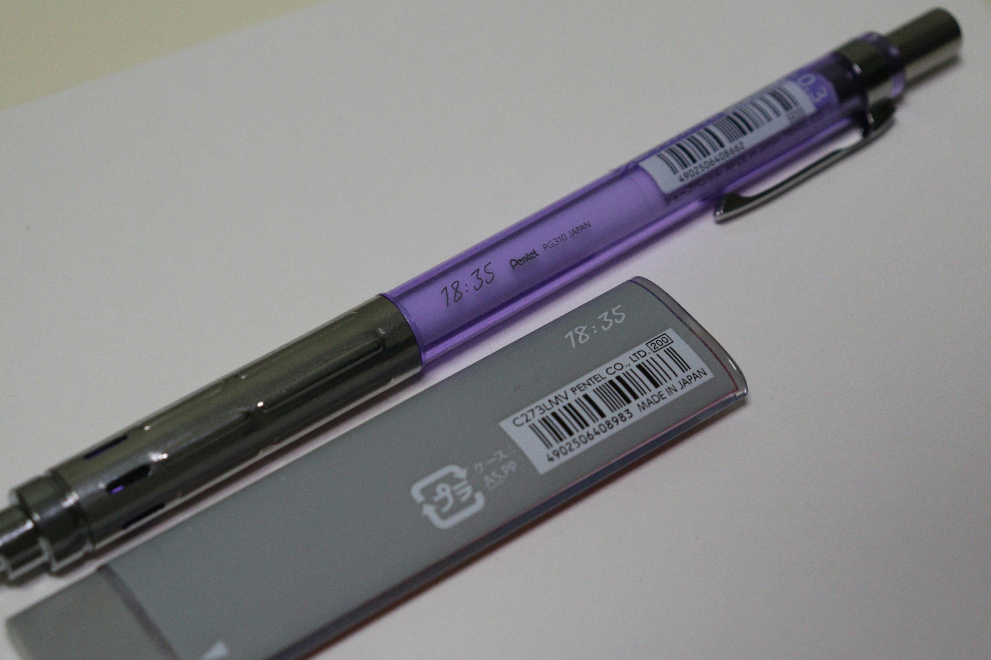 A purple pen and a gray eraser placed side by side