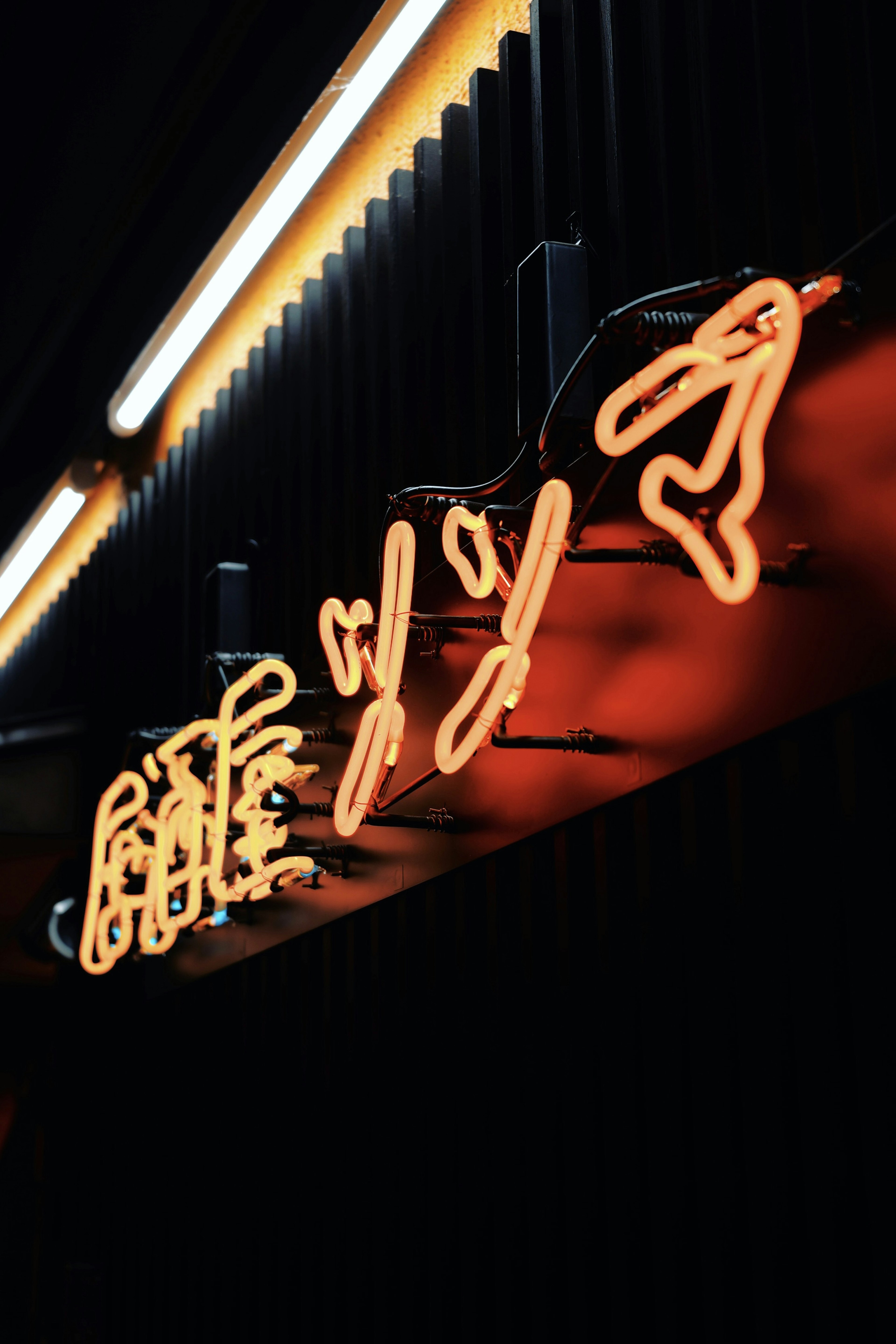 Insegna al neon arancione brillante con lettere stilizzate