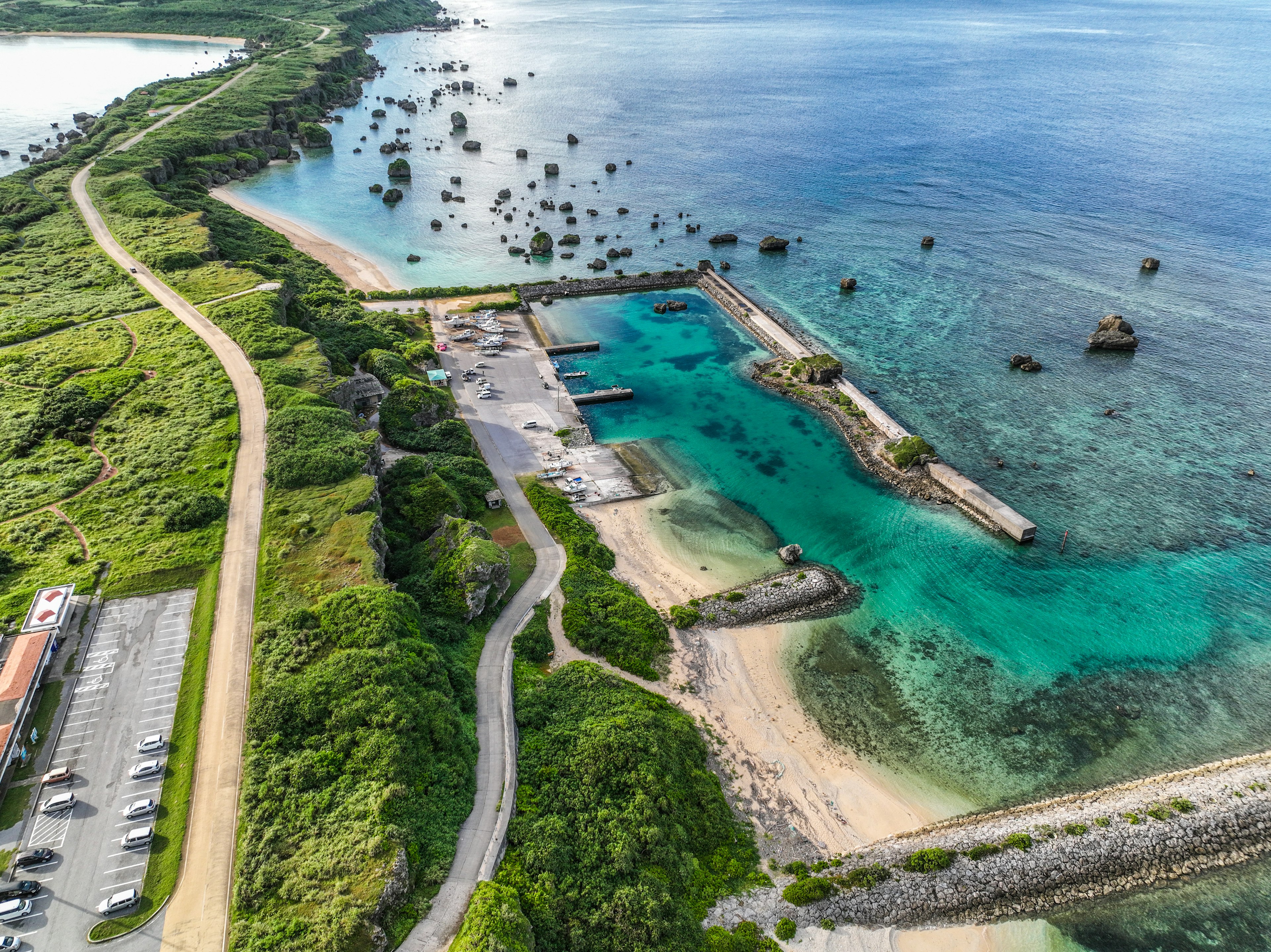 Pemandangan udara garis pantai yang indah dengan air biru dan perbukitan hijau yang mengelilingi teluk tenang