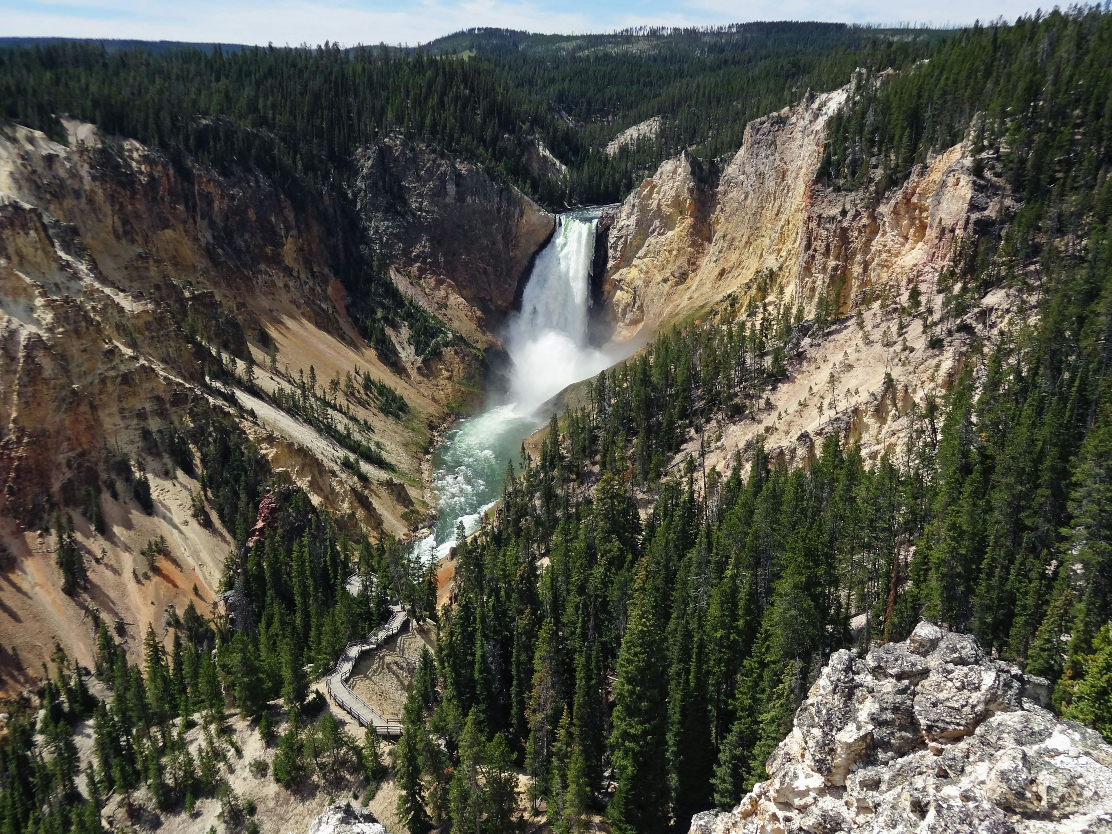 Impresionante vista de una cascada en el parque nacional de Yellowstone rodeada de árboles verdes