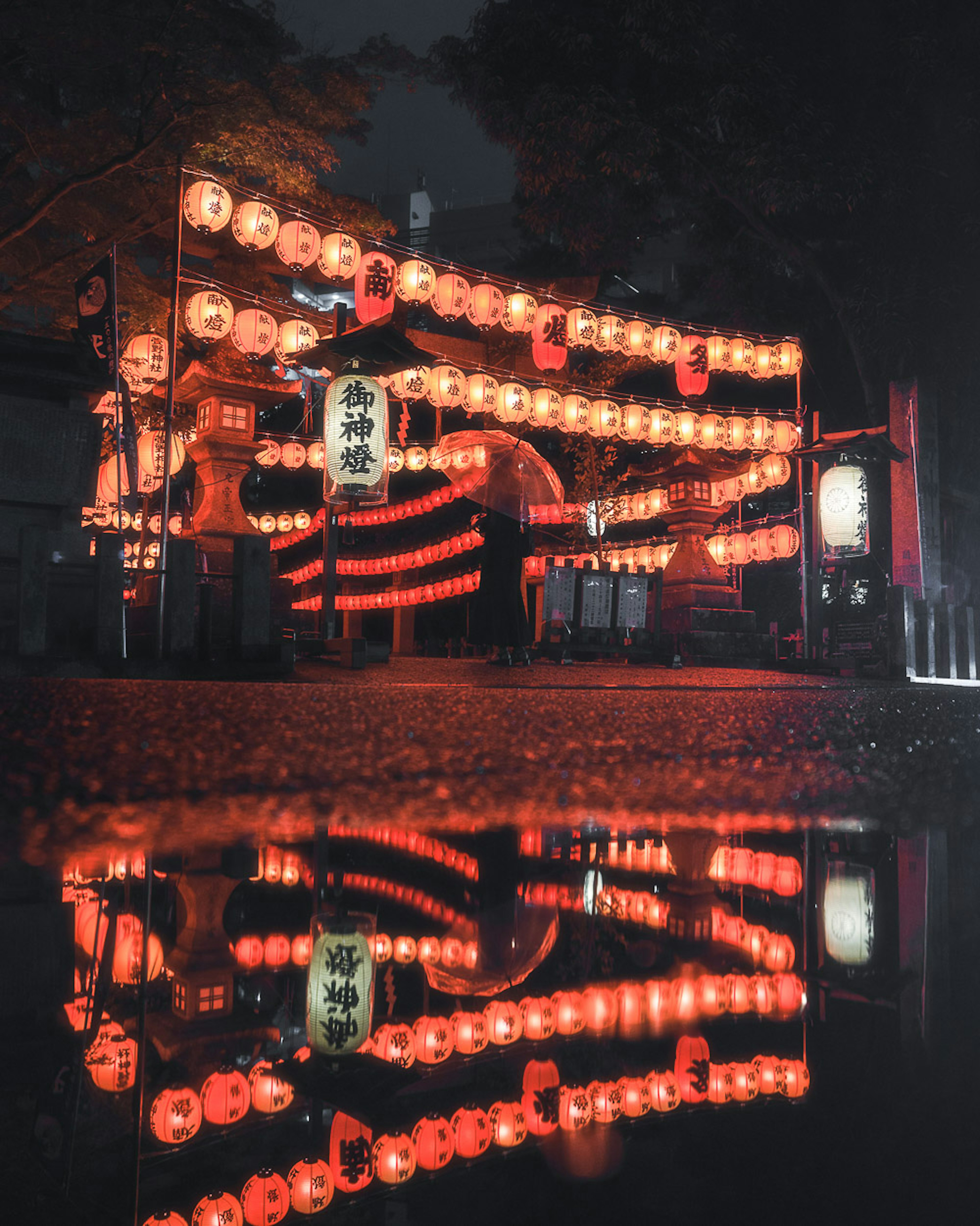 Scène magnifique de lanternes rouges lors d'un festival nocturne reflétant sur l'eau