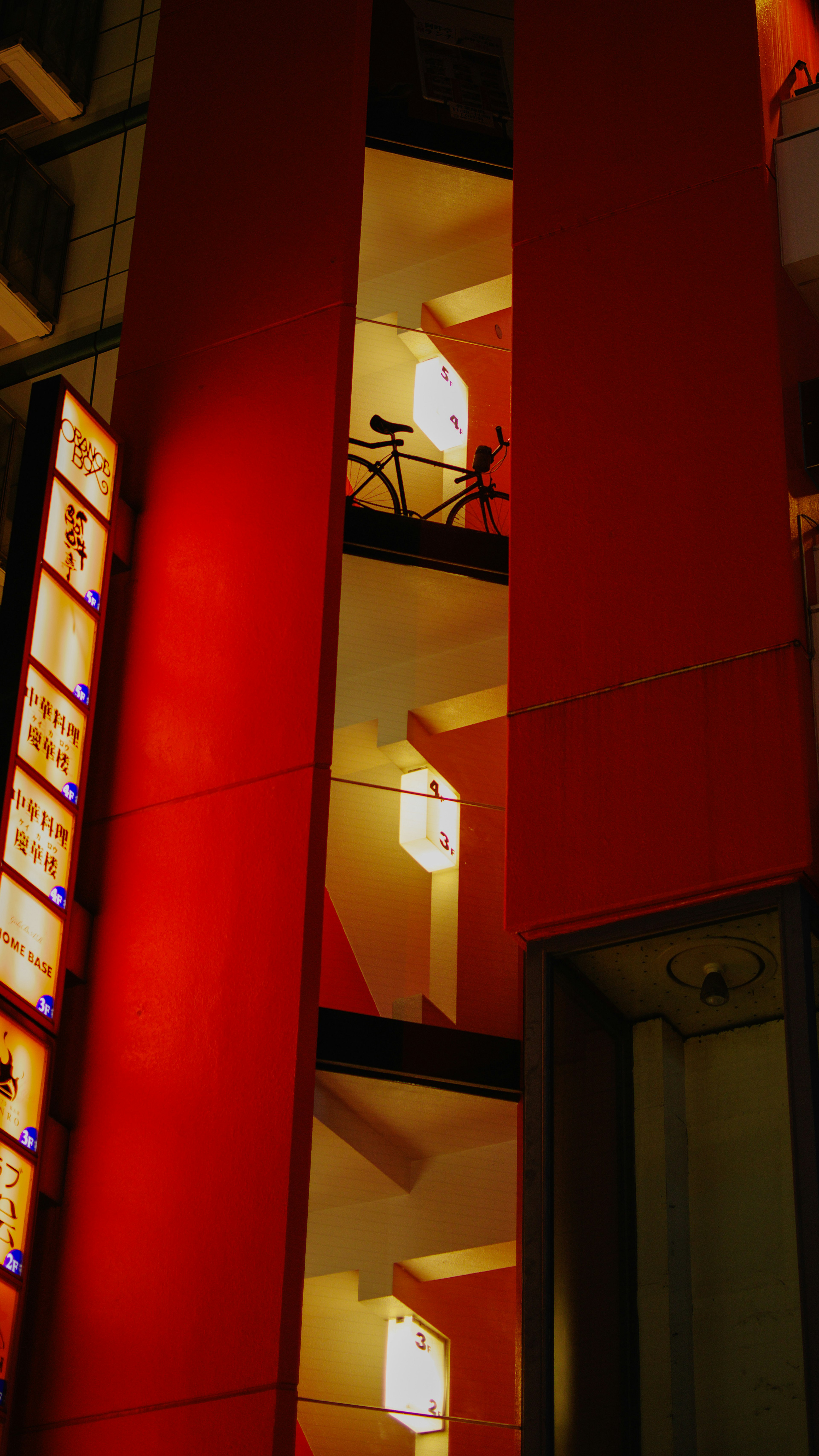 Edificio con paredes rojas que muestra escaleras y luces