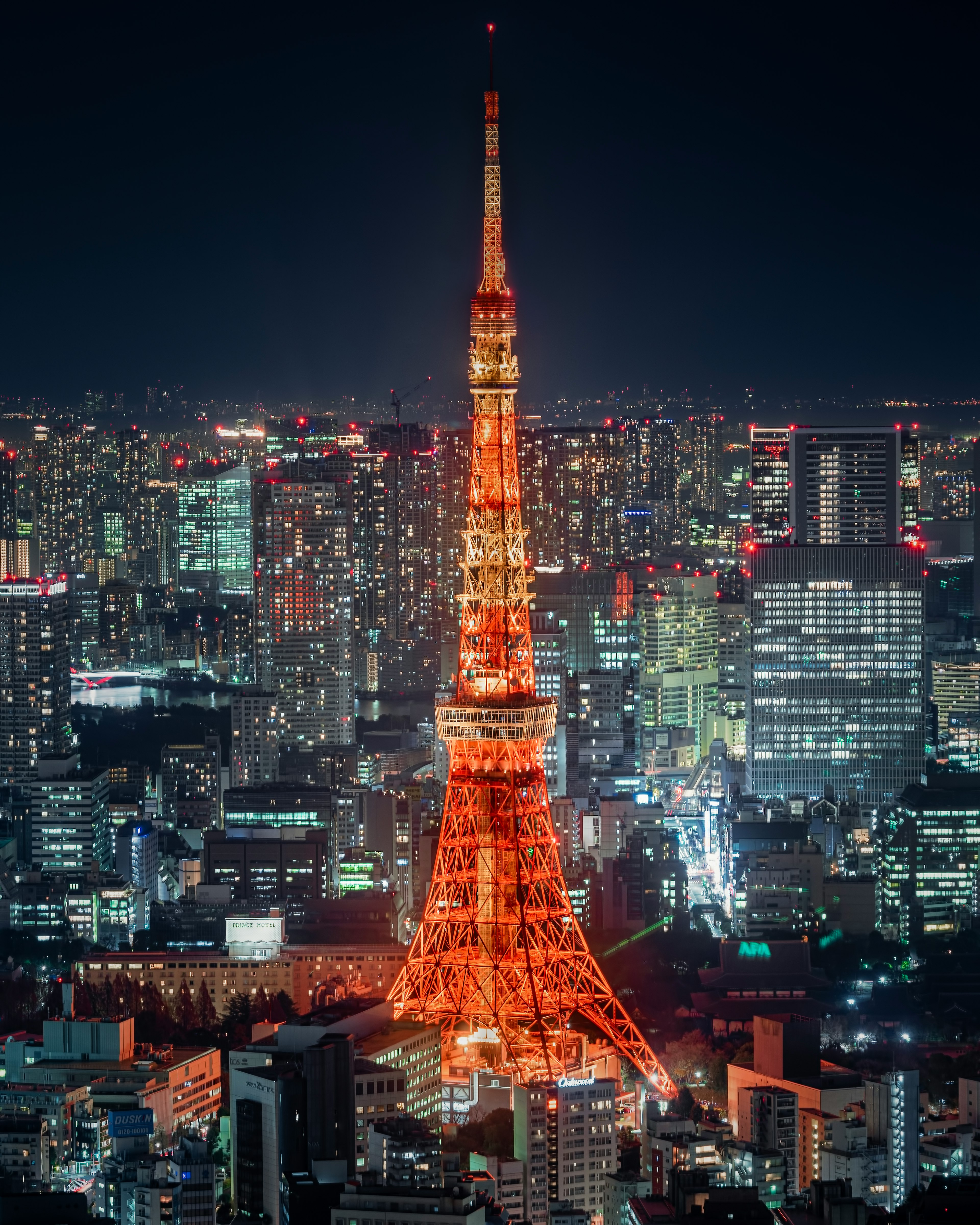 Tokyo Tower illuminated at night with a city skyline