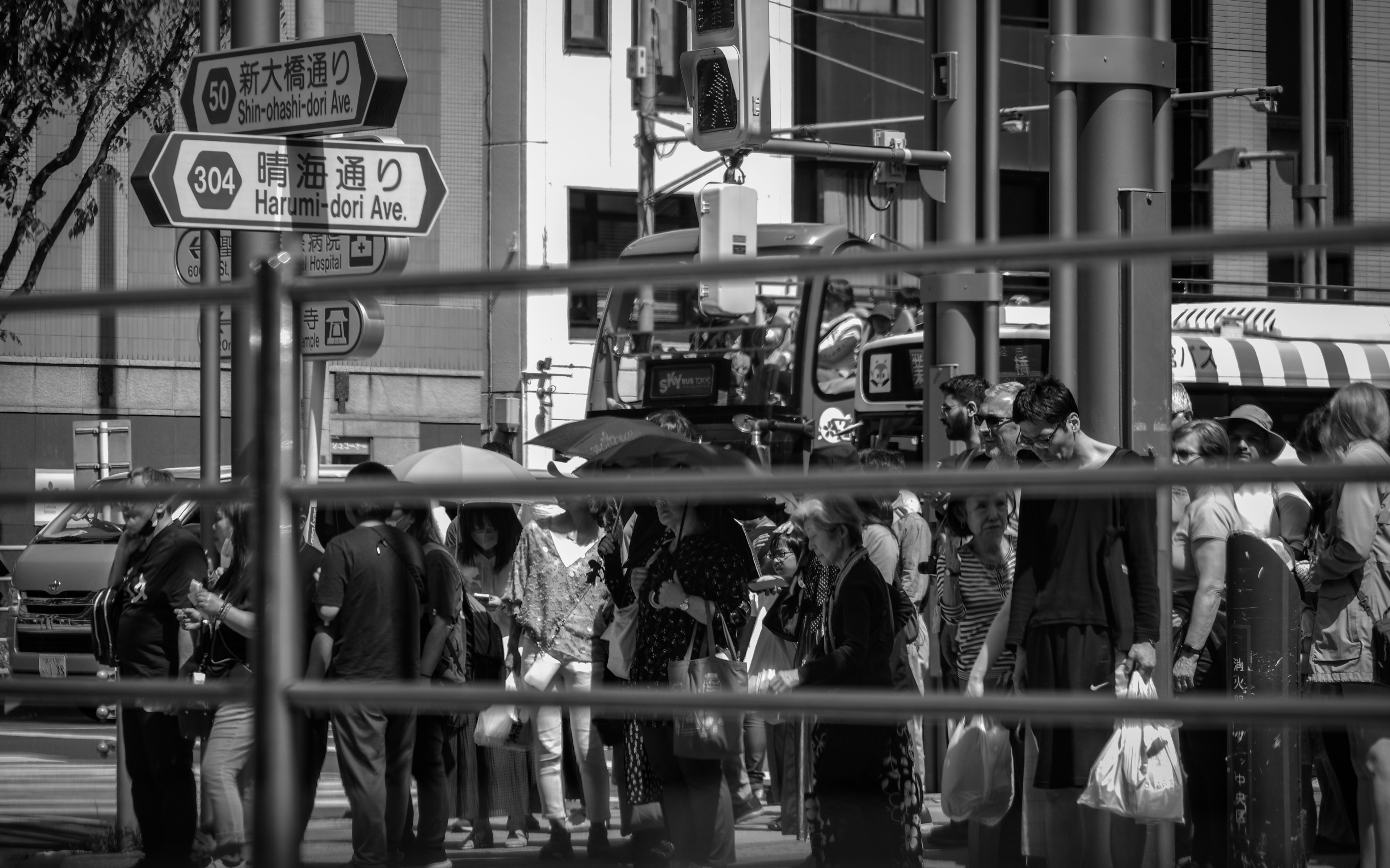 Une foule de personnes avec des parapluies rassemblées dans un environnement urbain en noir et blanc