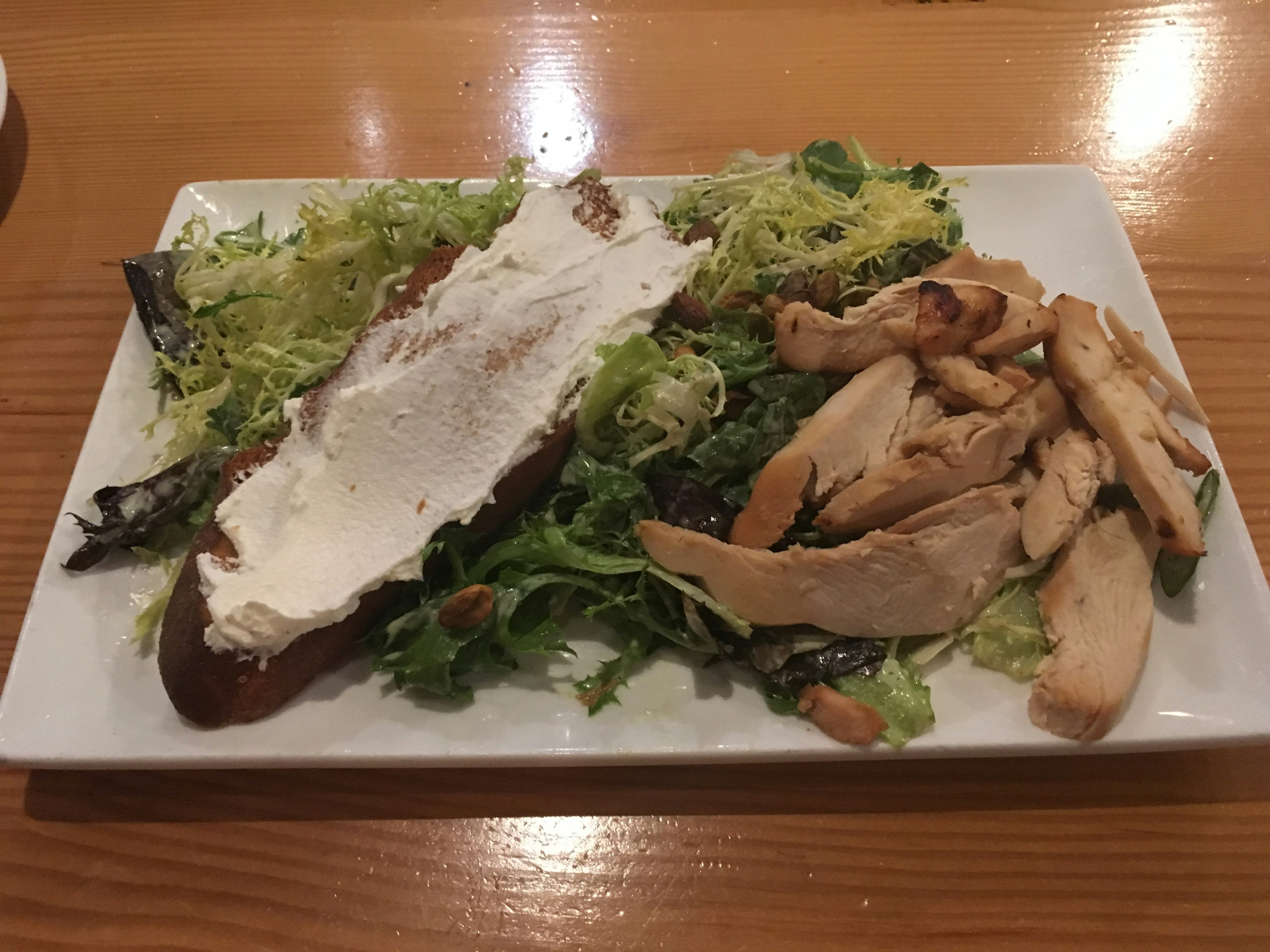 Piatto di insalata con pollo a fette e guarnizione di formaggio spalmabile