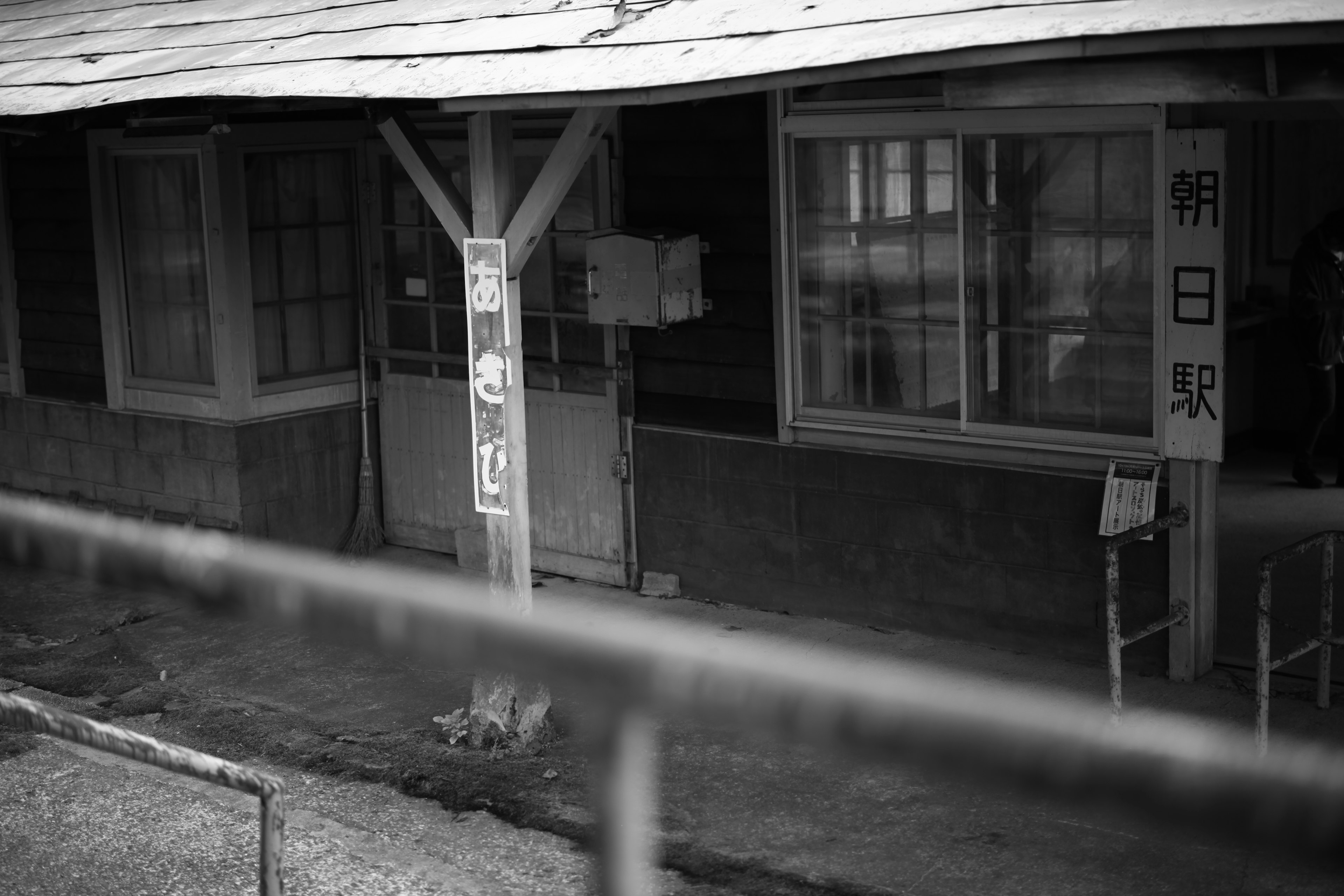 Foto en blanco y negro de una antigua estación de tren con ventanas y letreros visibles