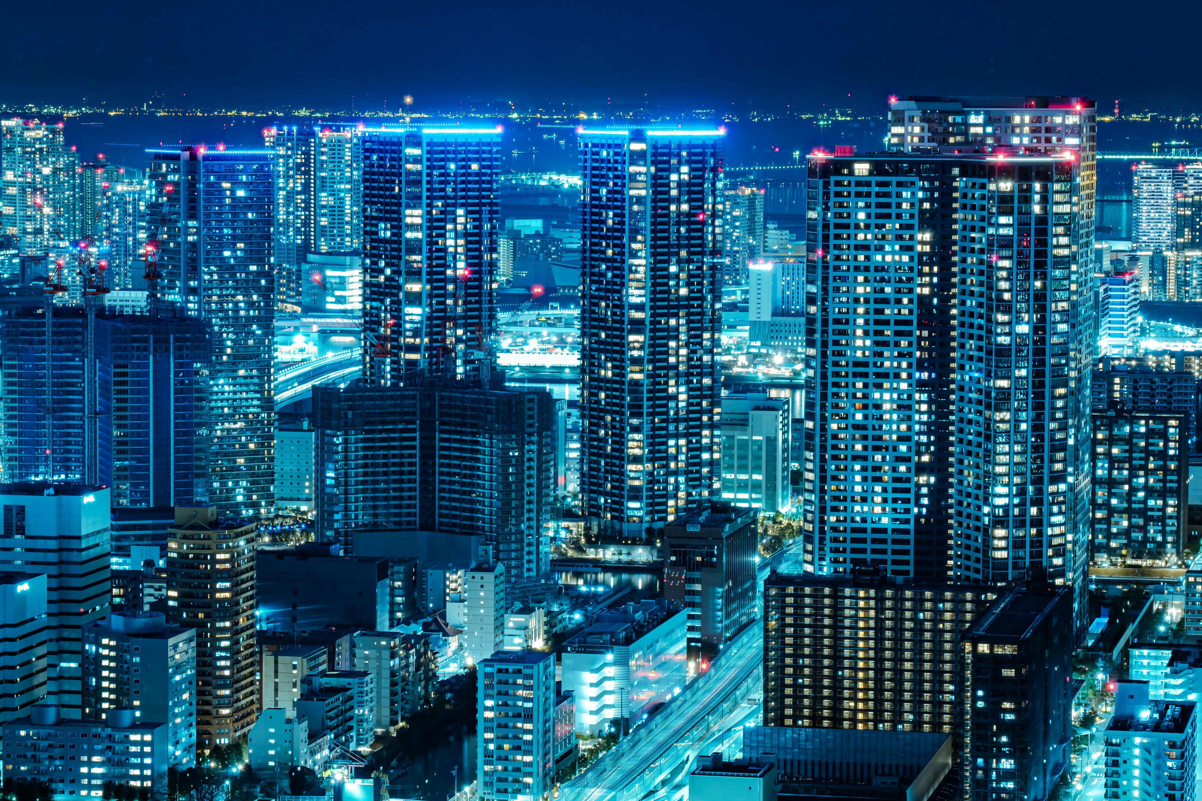 Night cityscape with skyscrapers illuminated in blue light