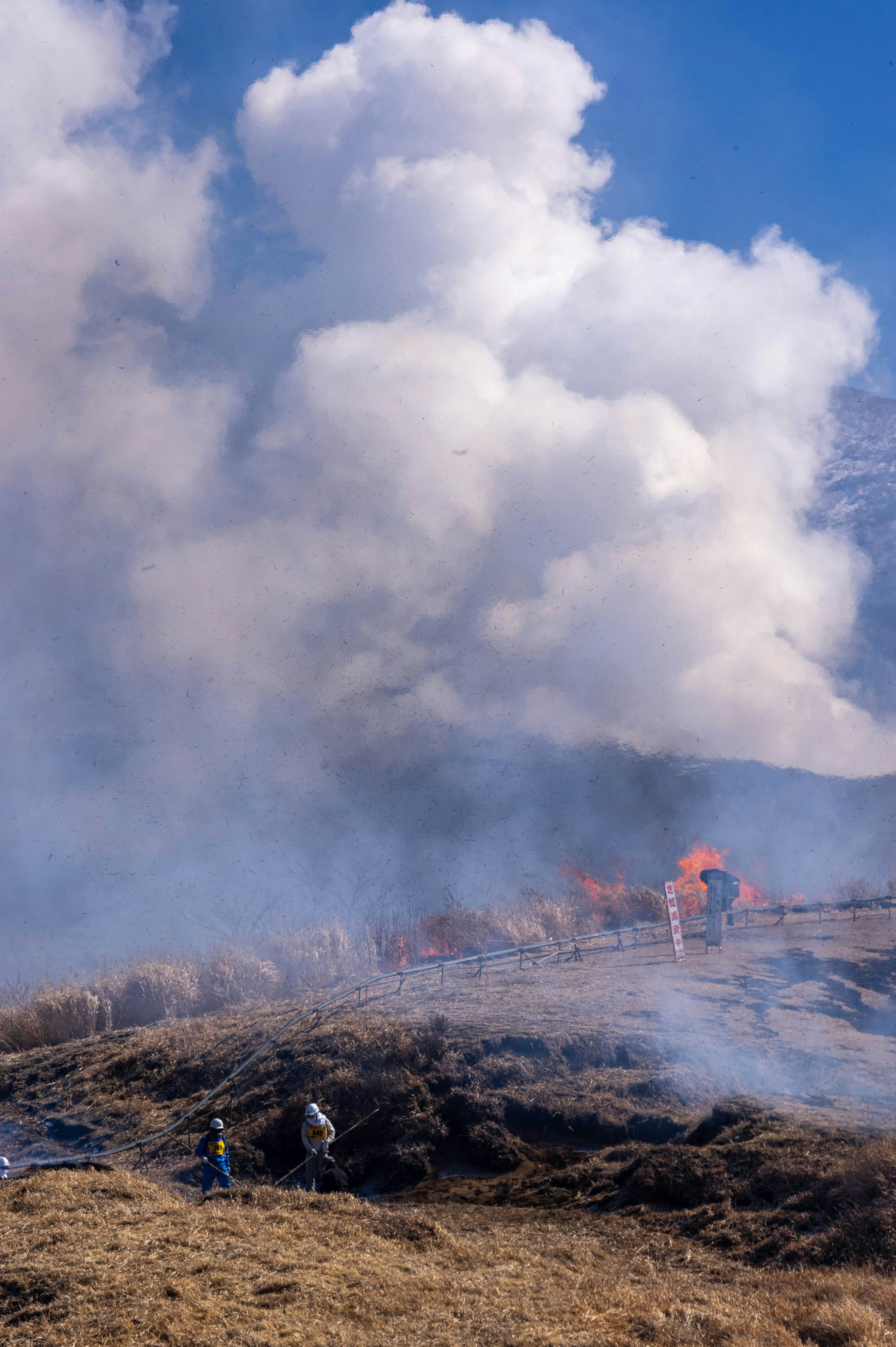 Paisaje con personas trabajando entre humo y fuego