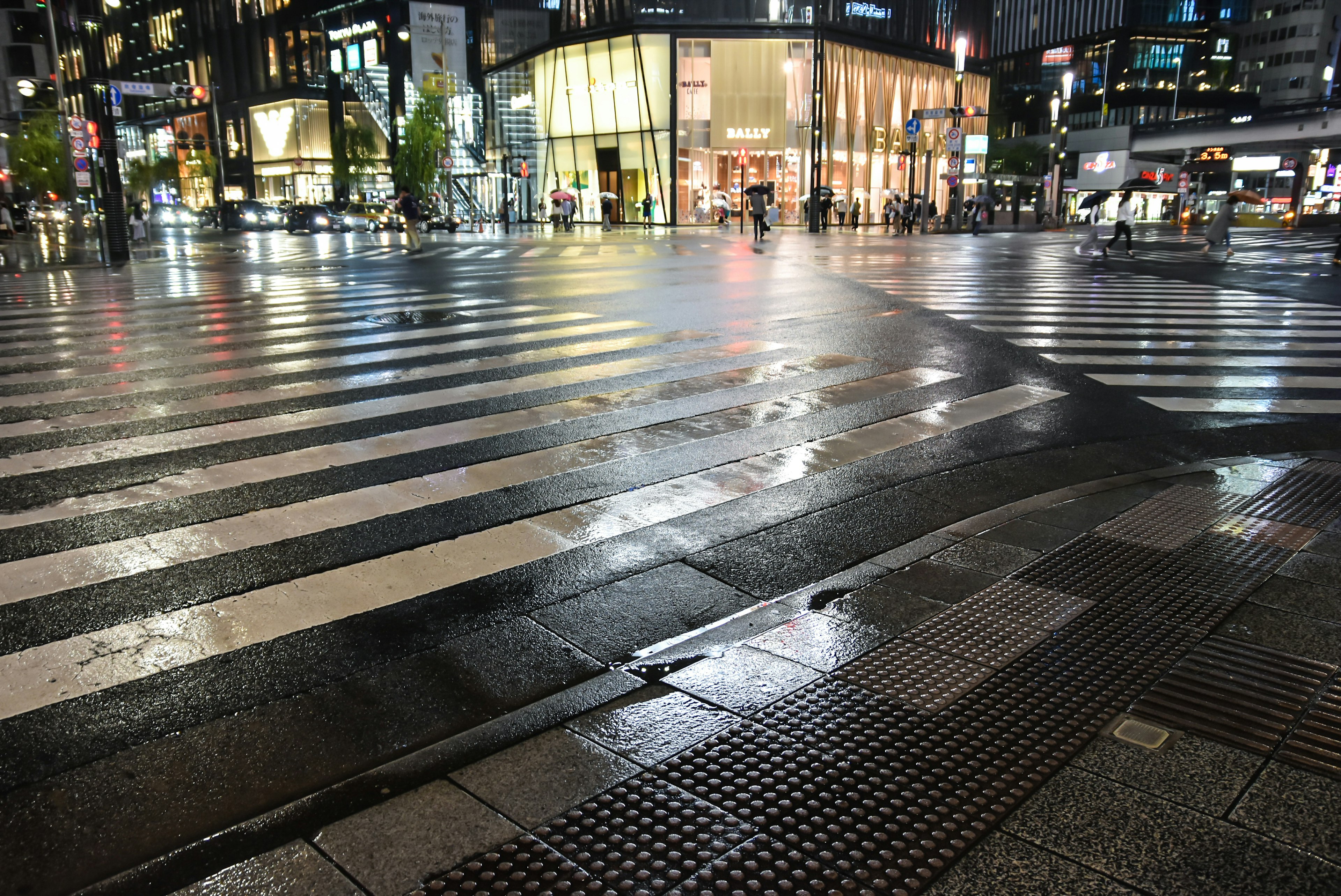 Passage piéton humide reflétant les lumières de la ville la nuit