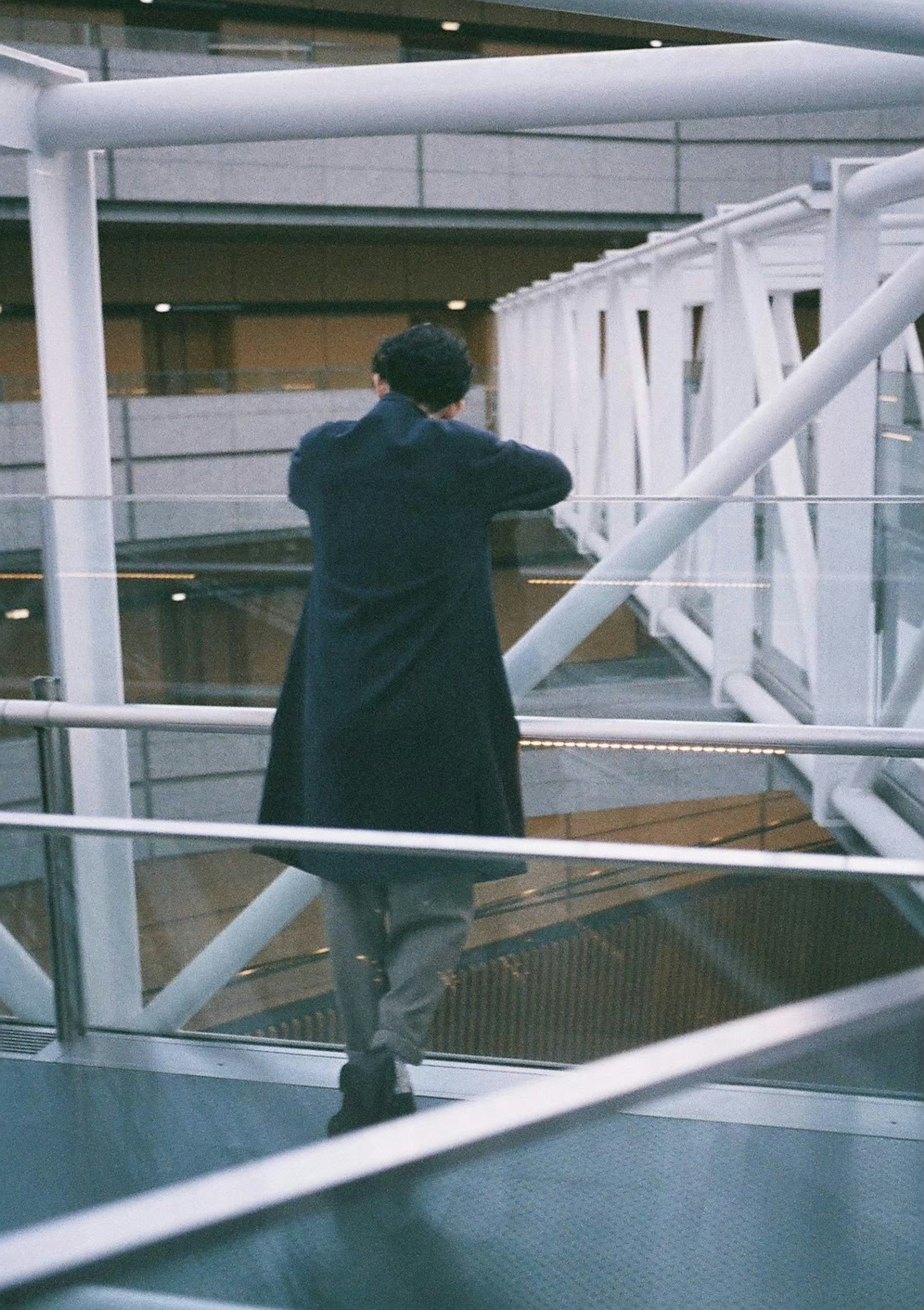 Homme debout près de la balustrade blanche dans l'intérieur d'un bâtiment moderne